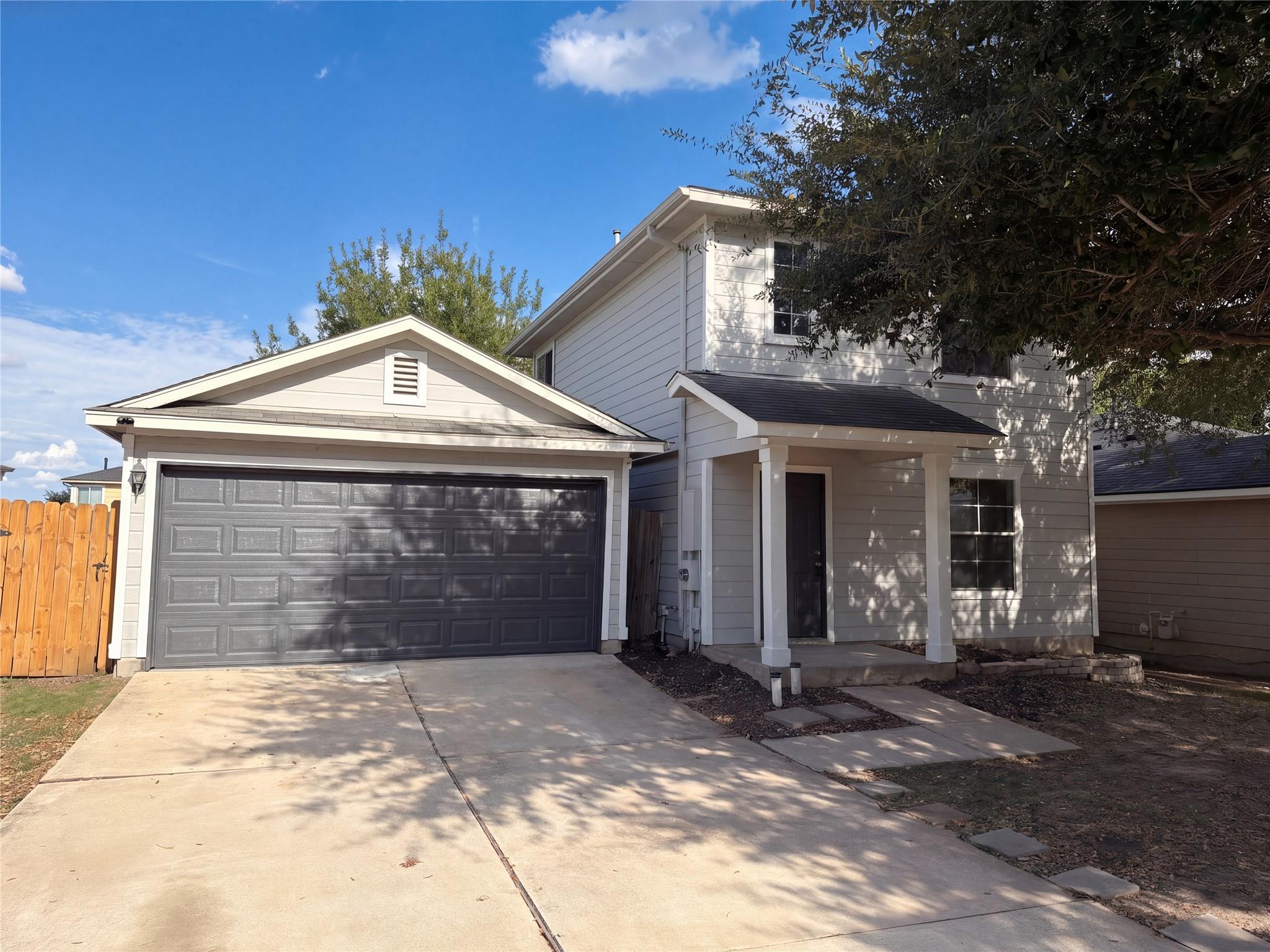 A spacious driveway and charming front porch welc
