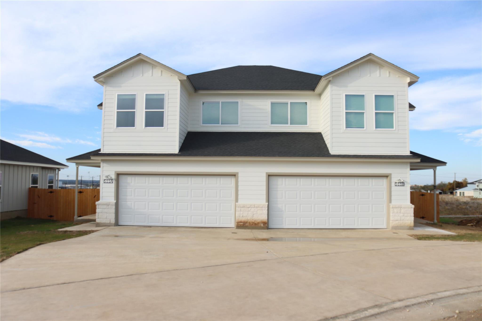 Crisp white siding and stone accents define this 