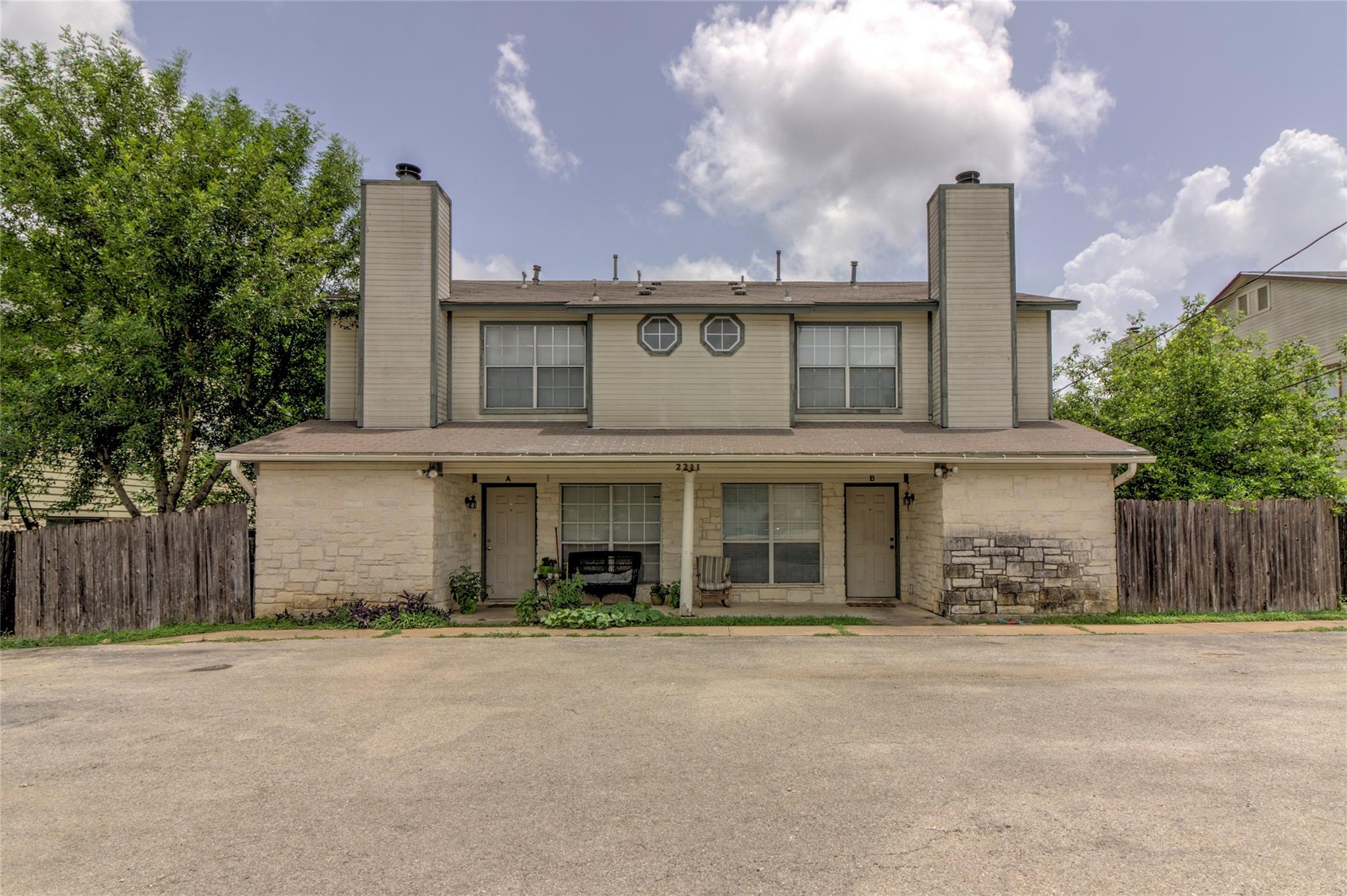 Traditional home featuring a chimney, stone sidin