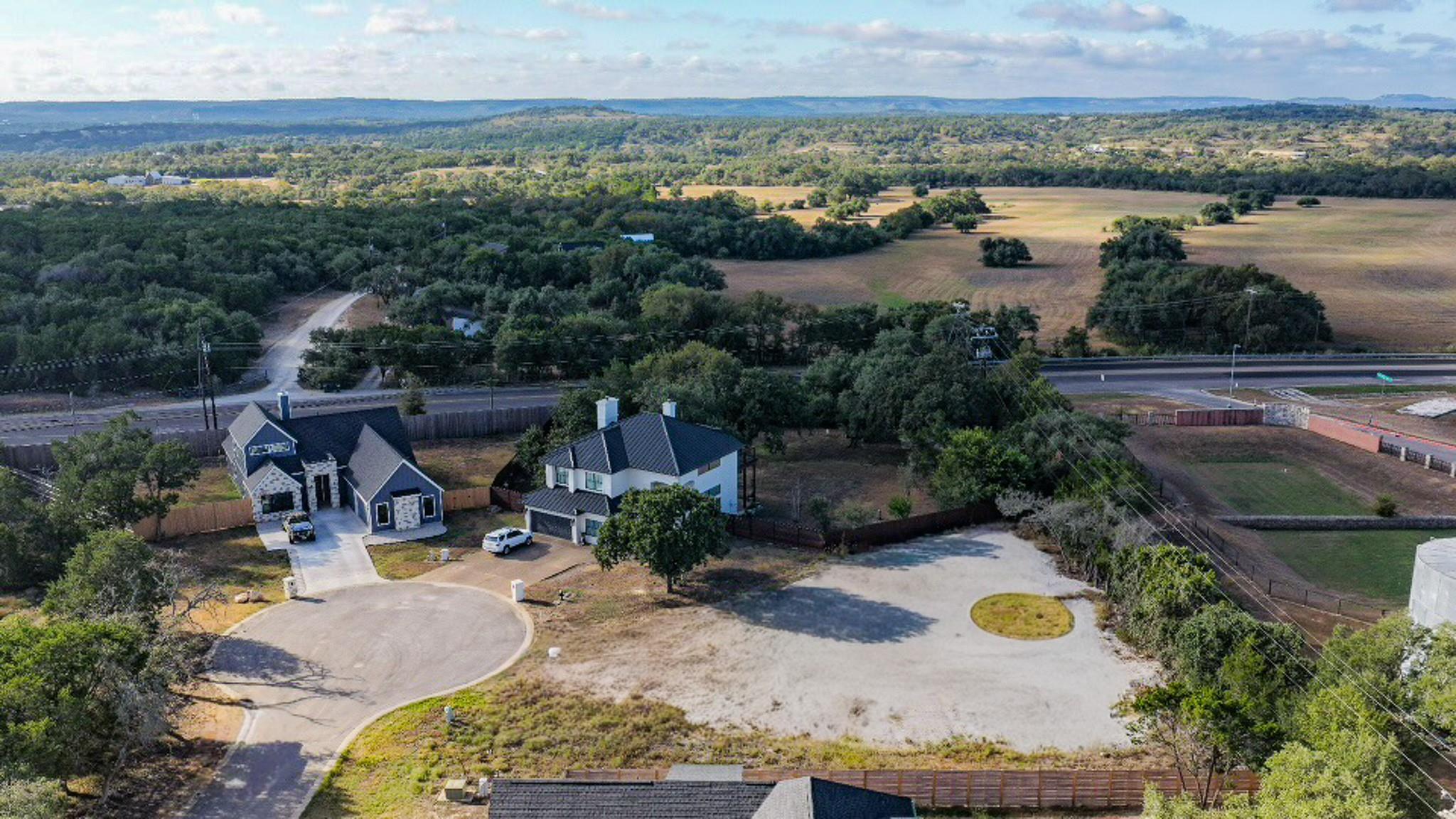 Rolling hills and mature trees create a scenic ba