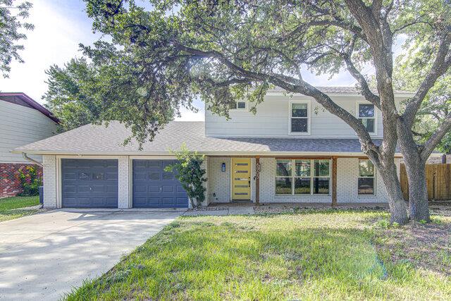 Mature trees frame this classic two-story facade 