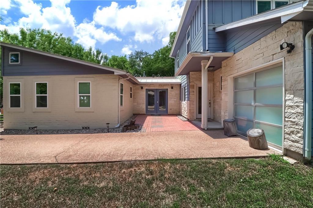 A spacious driveway and multi-textured facade hig
