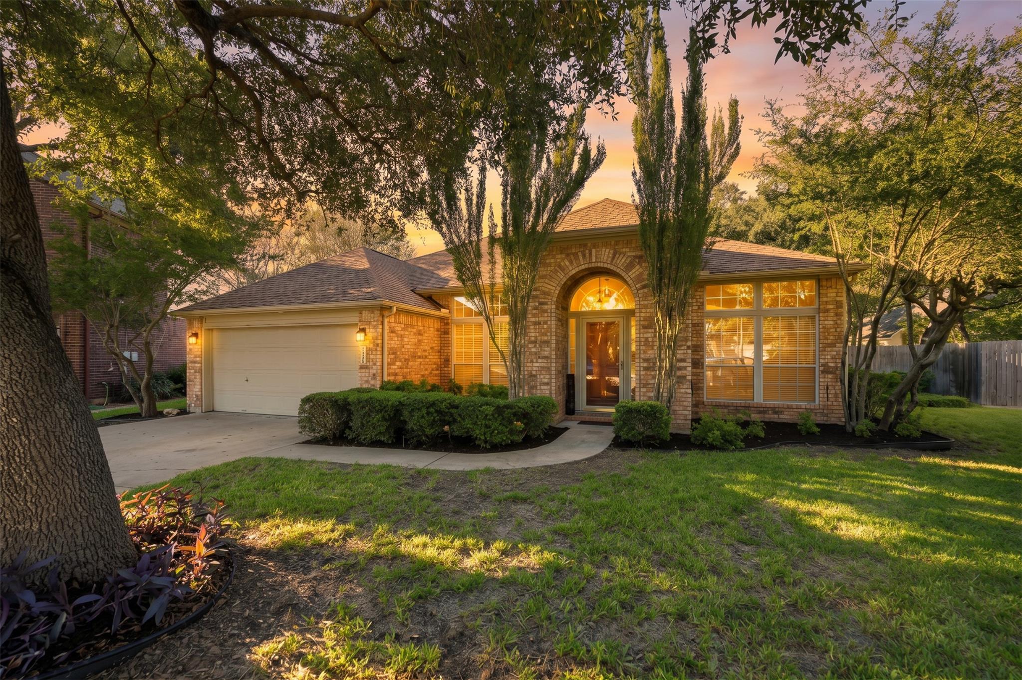 Mature trees frame a classic brick exterior featu