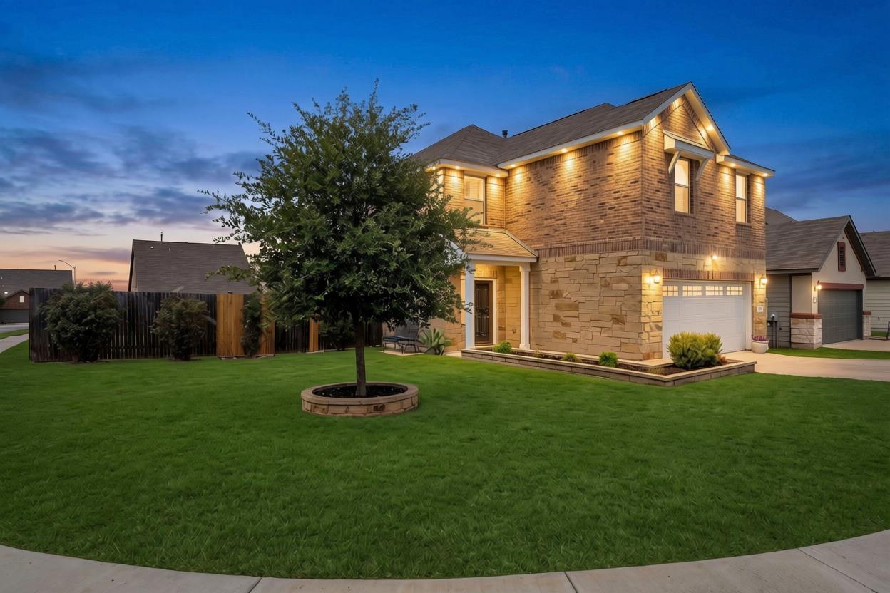 A well-manicured green lawn frames this two-story