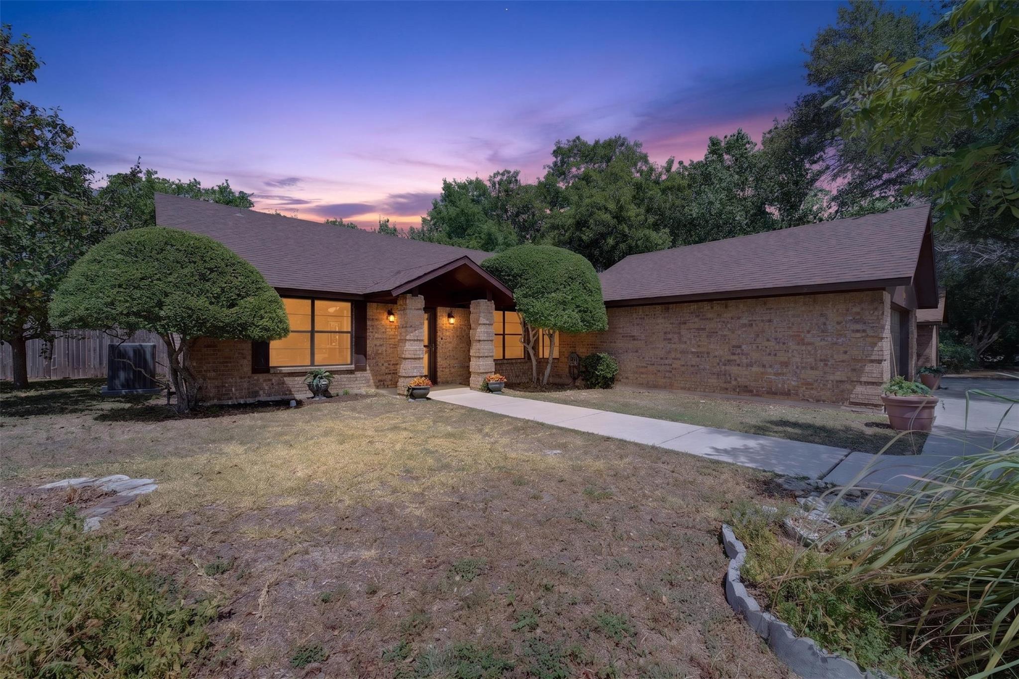 Mature trees frame a classic stone exterior under