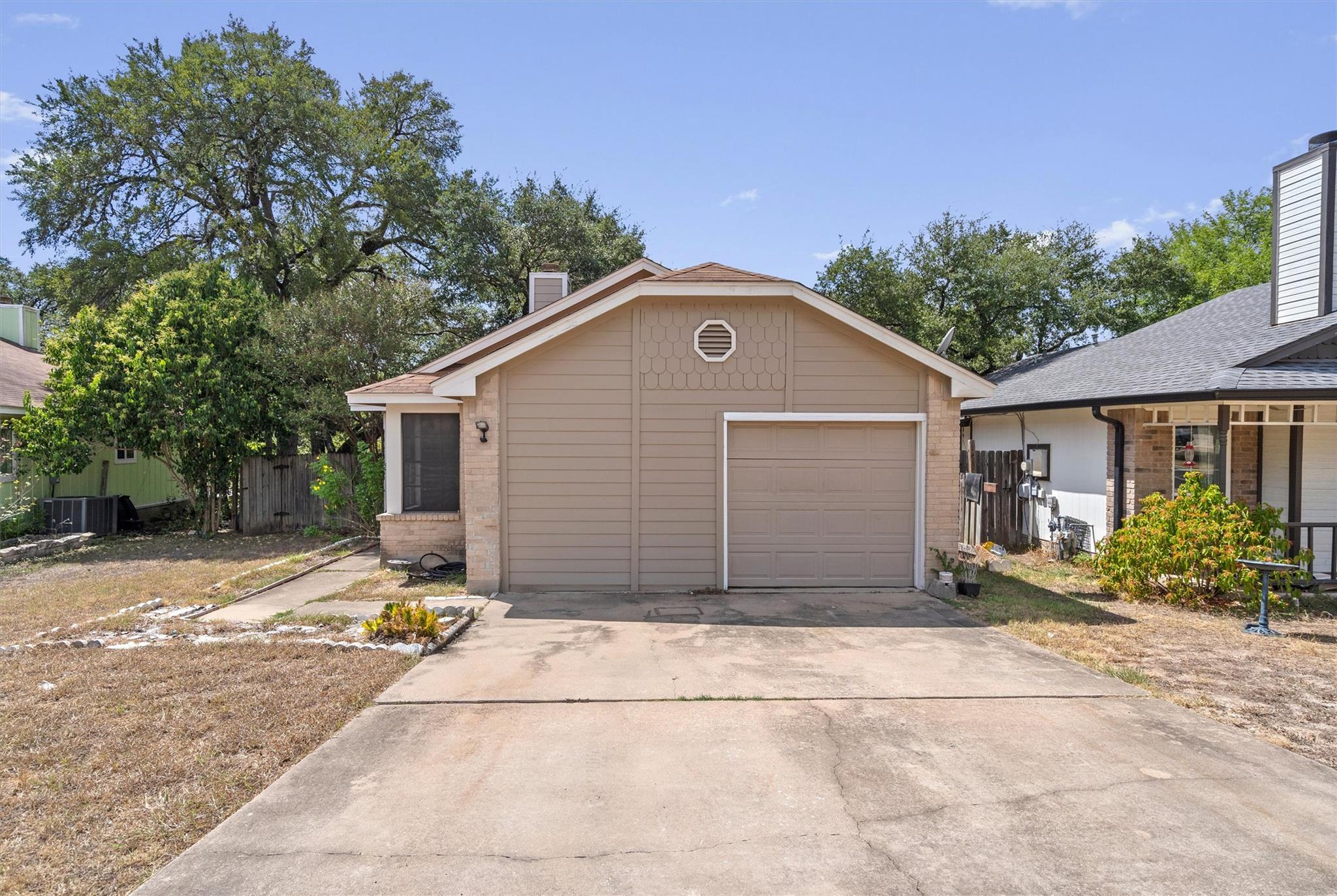A classic concrete driveway leads directly to a s