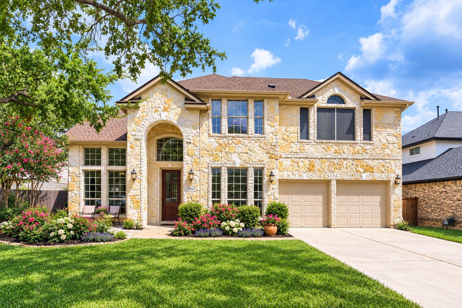 A classic stone facade with double garage doors h