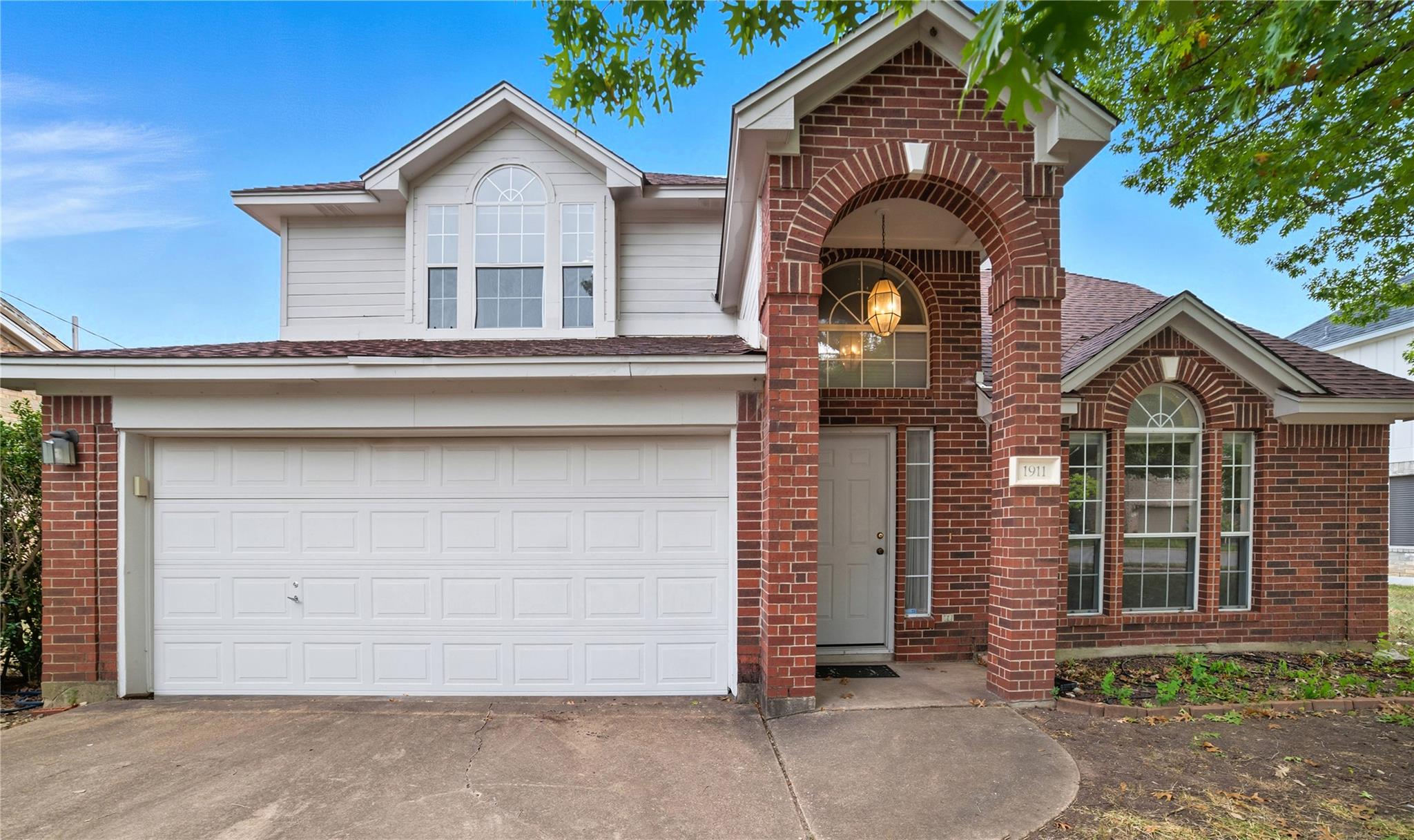 Traditional-style home with driveway, brick sidin