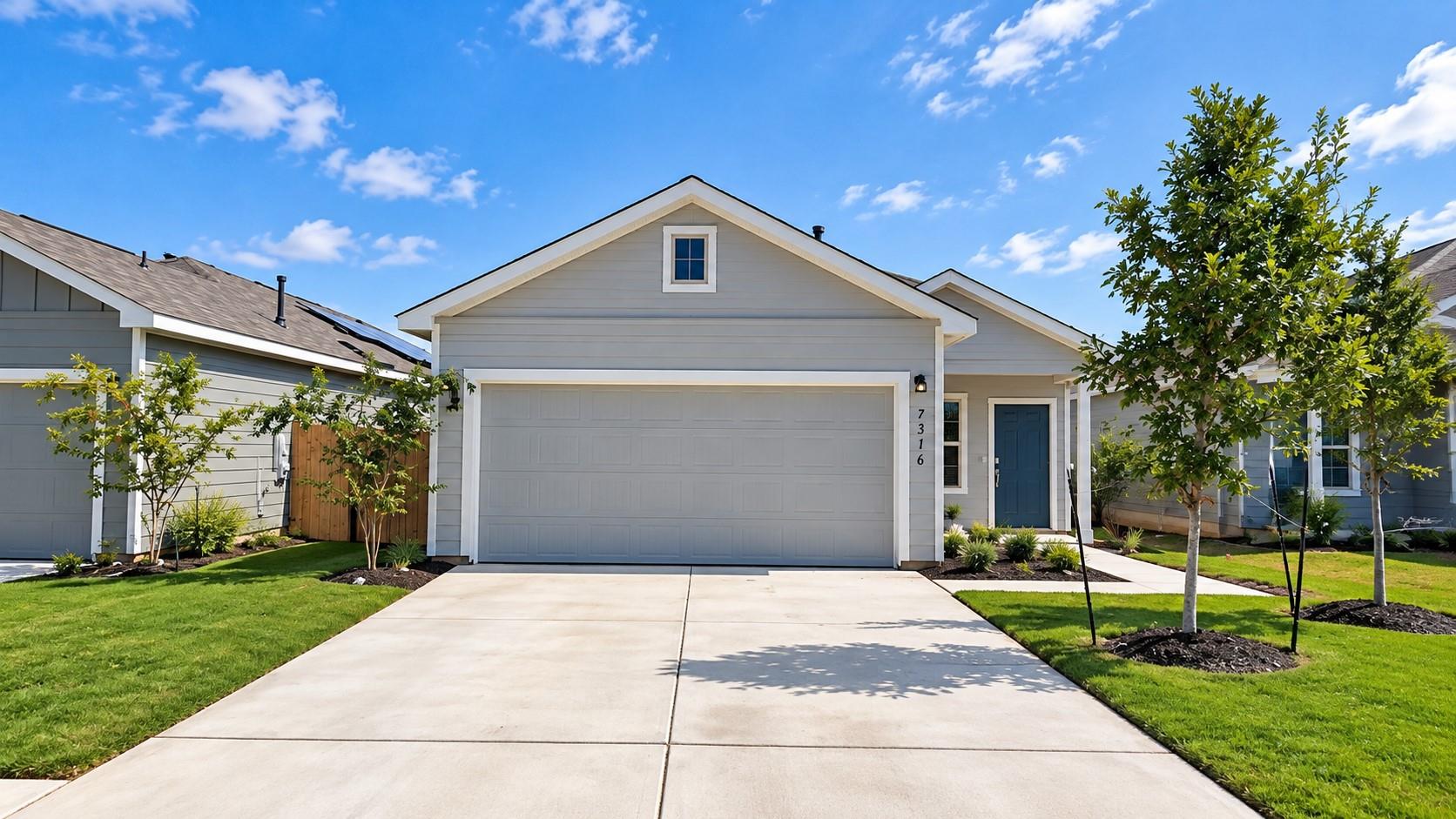 A concrete driveway leads to the front-loading ga