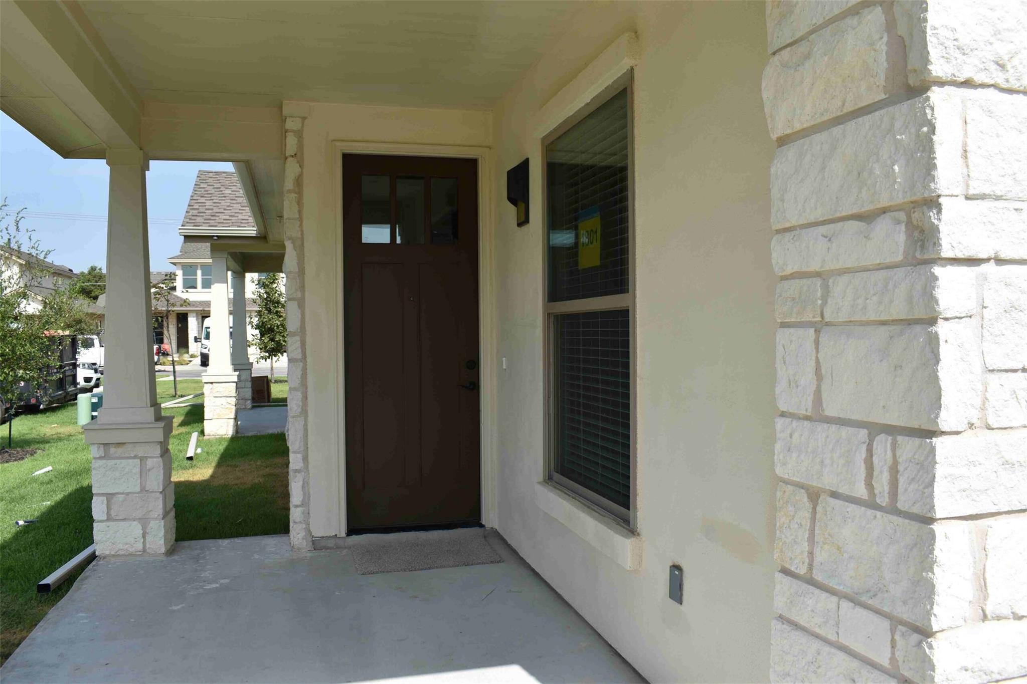 A welcoming front porch features clean concrete f