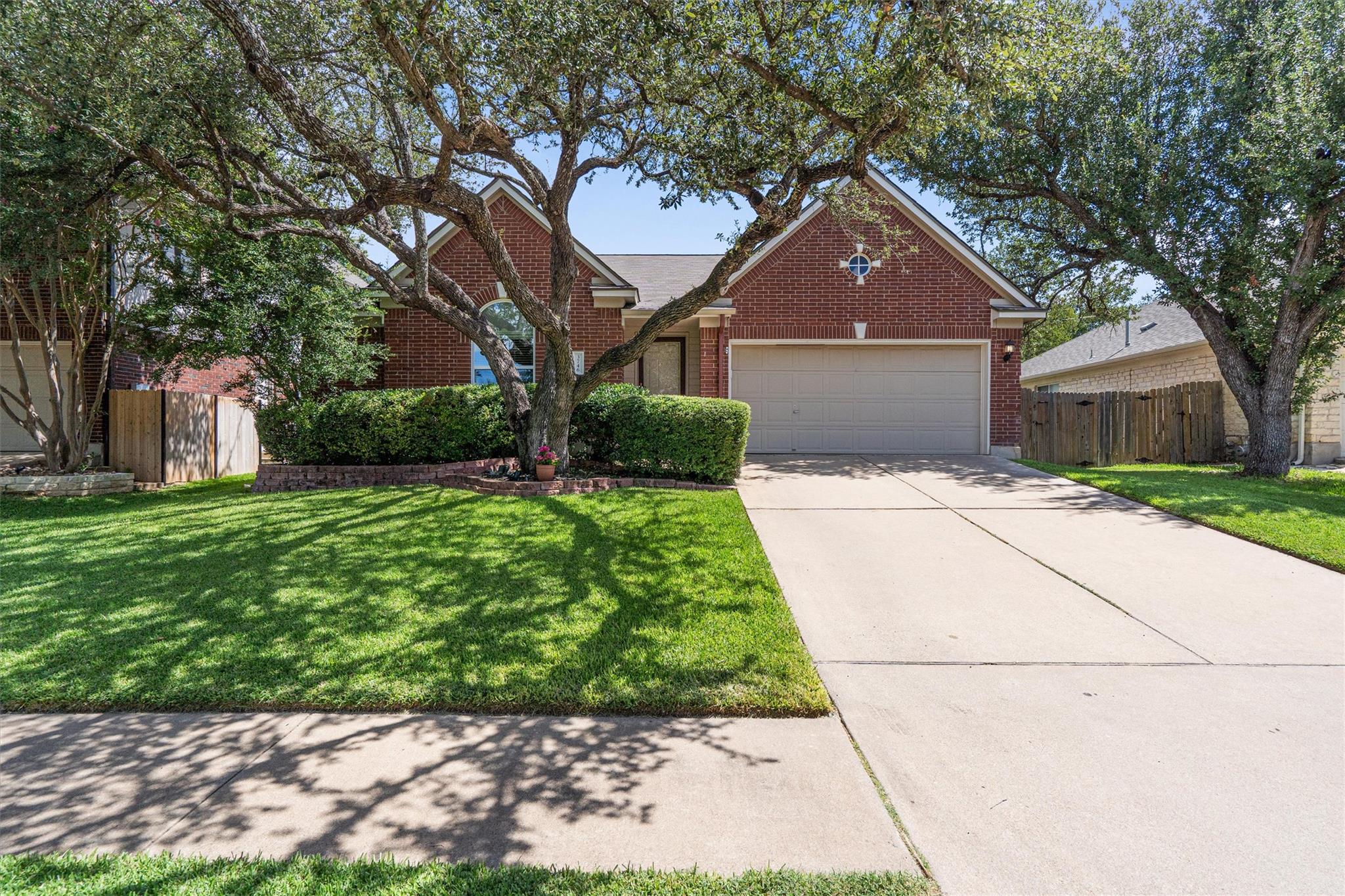 Mature trees shade a classic brick exterior compl