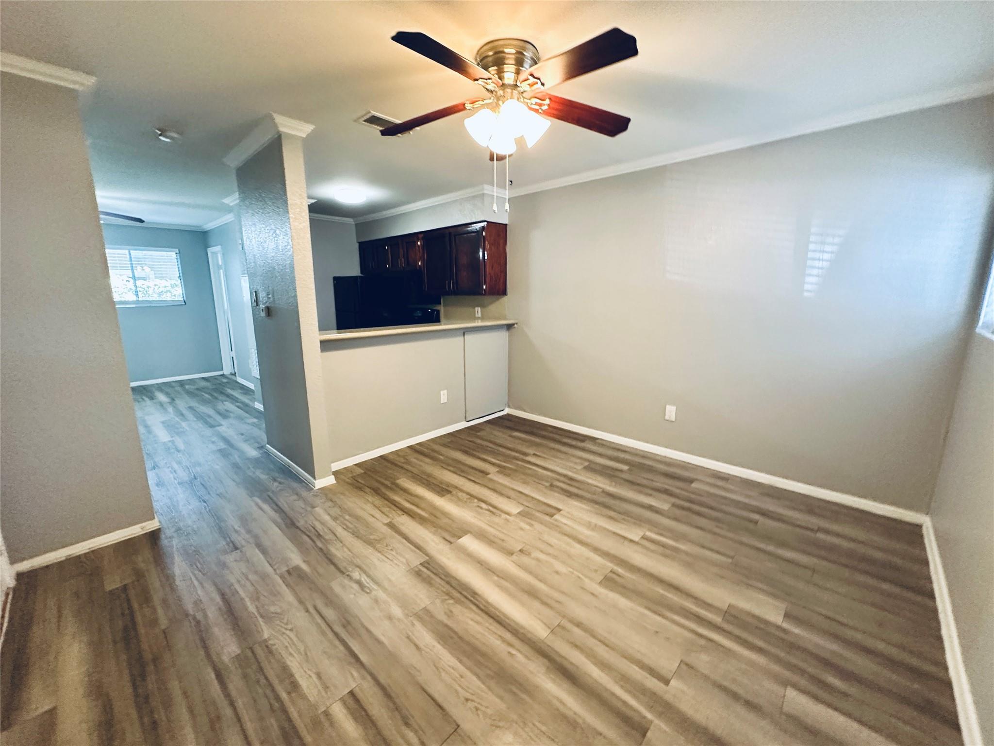 Warm wood-look flooring and crown molding define 