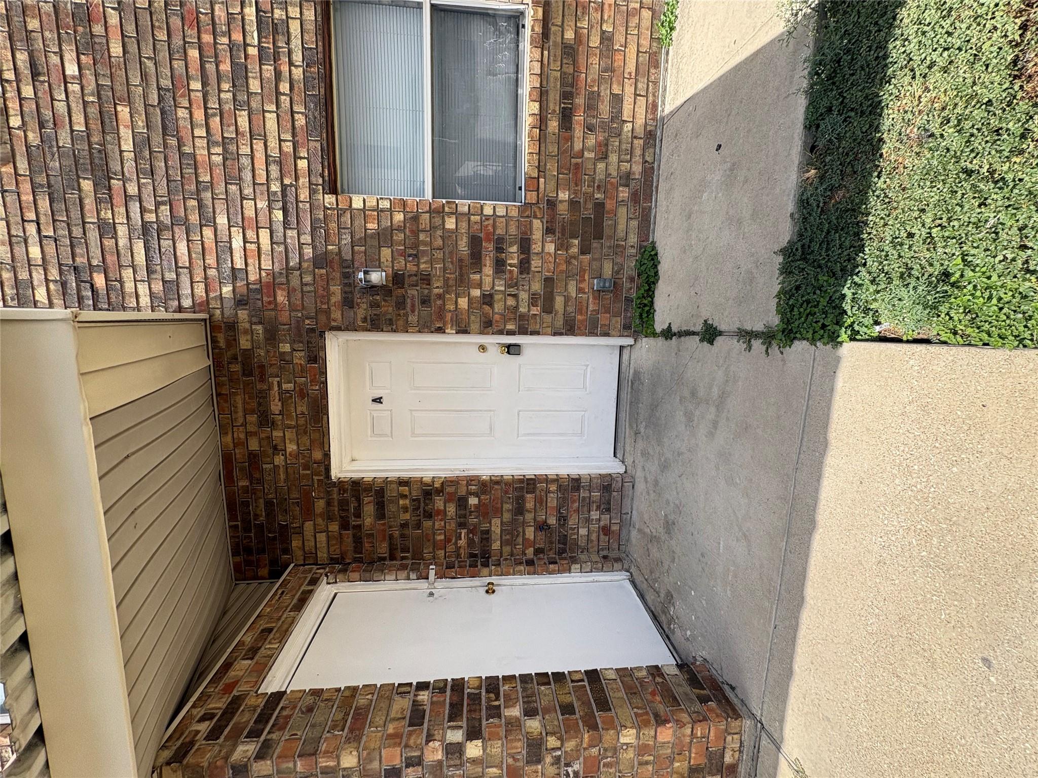 A classic brick exterior framed by concrete walkw