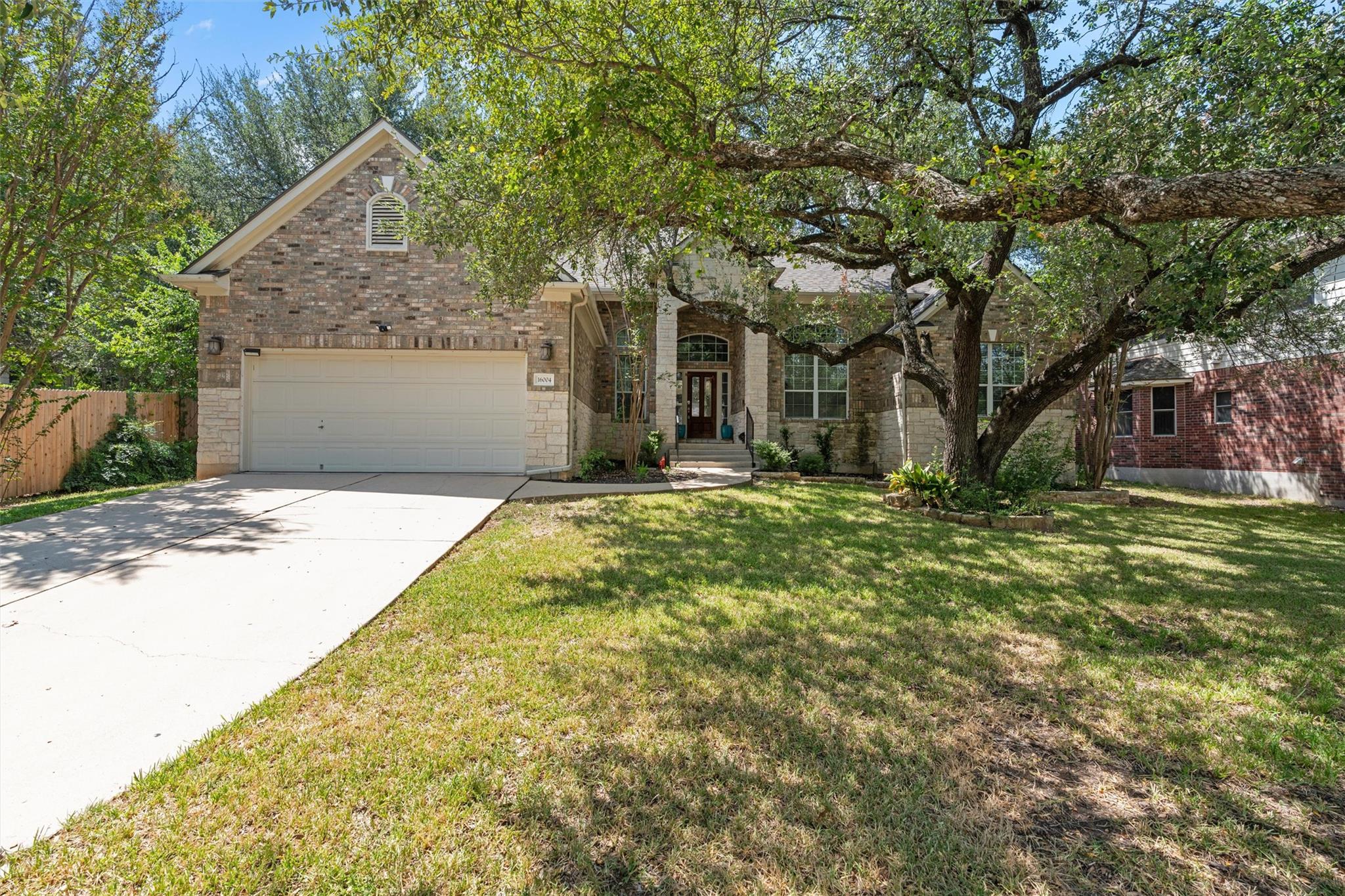 Mature shade trees frame a classic brick exterior