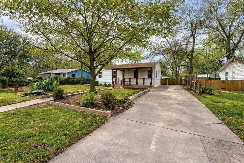 Mature trees shade the concrete driveway and welc