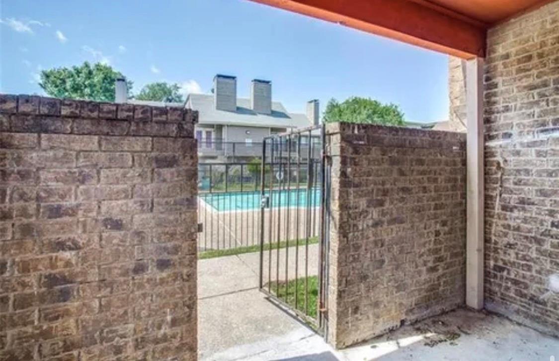 An enclosed brick patio offers direct gated acces