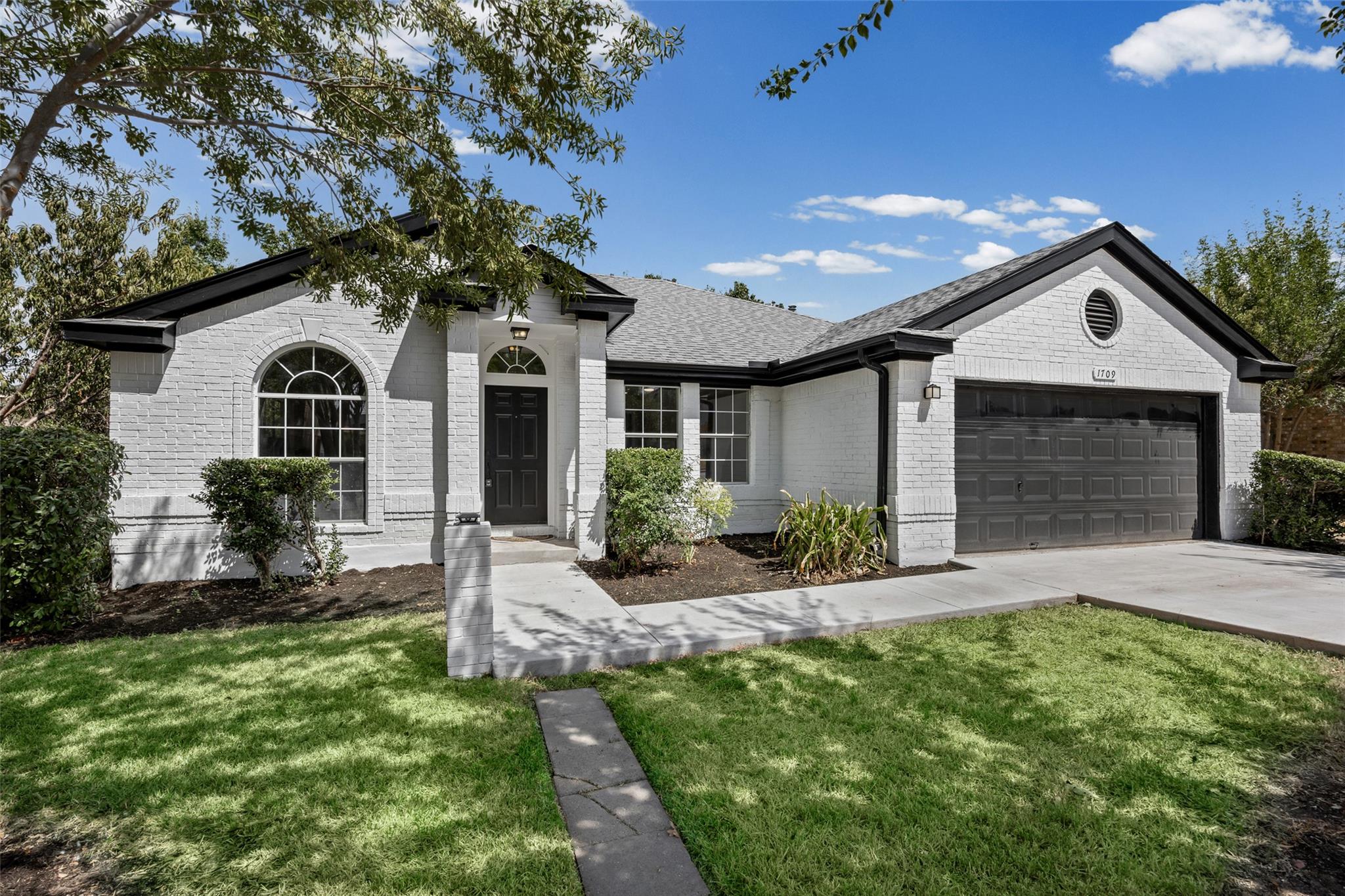 Crisp white brickwork and dark trim define this c