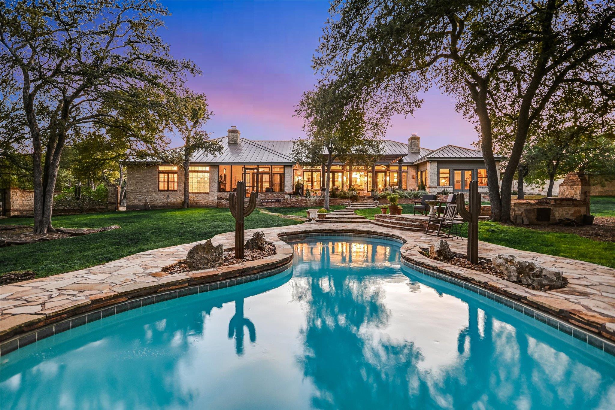 Mature trees frame a sparkling pool set against a