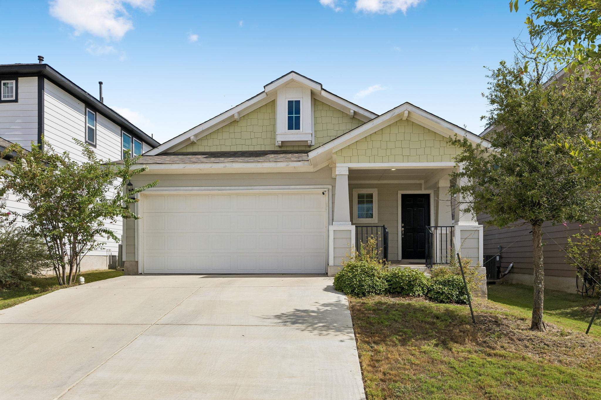 A concrete driveway leads to a welcoming front po