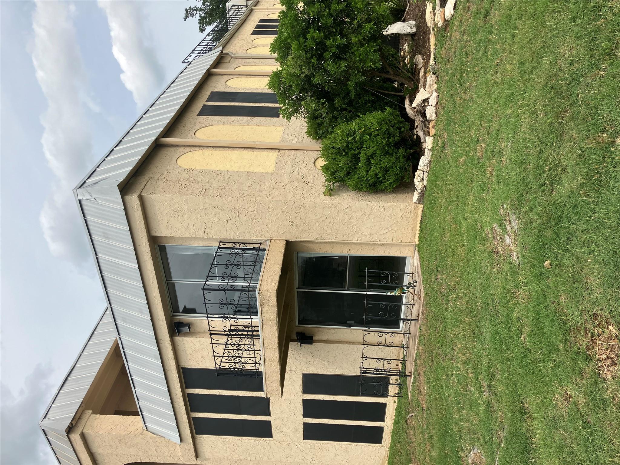 Multi-level stucco exterior showcases a metal roo