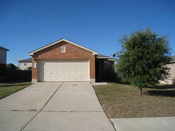 A long concrete driveway leads to a classic brick