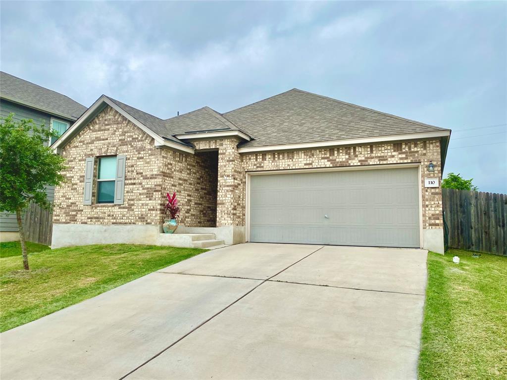A classic brick exterior and concrete driveway le