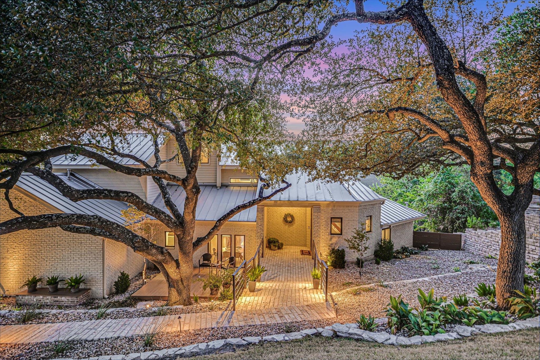 Mature oak trees frame a modern multi-level resid
