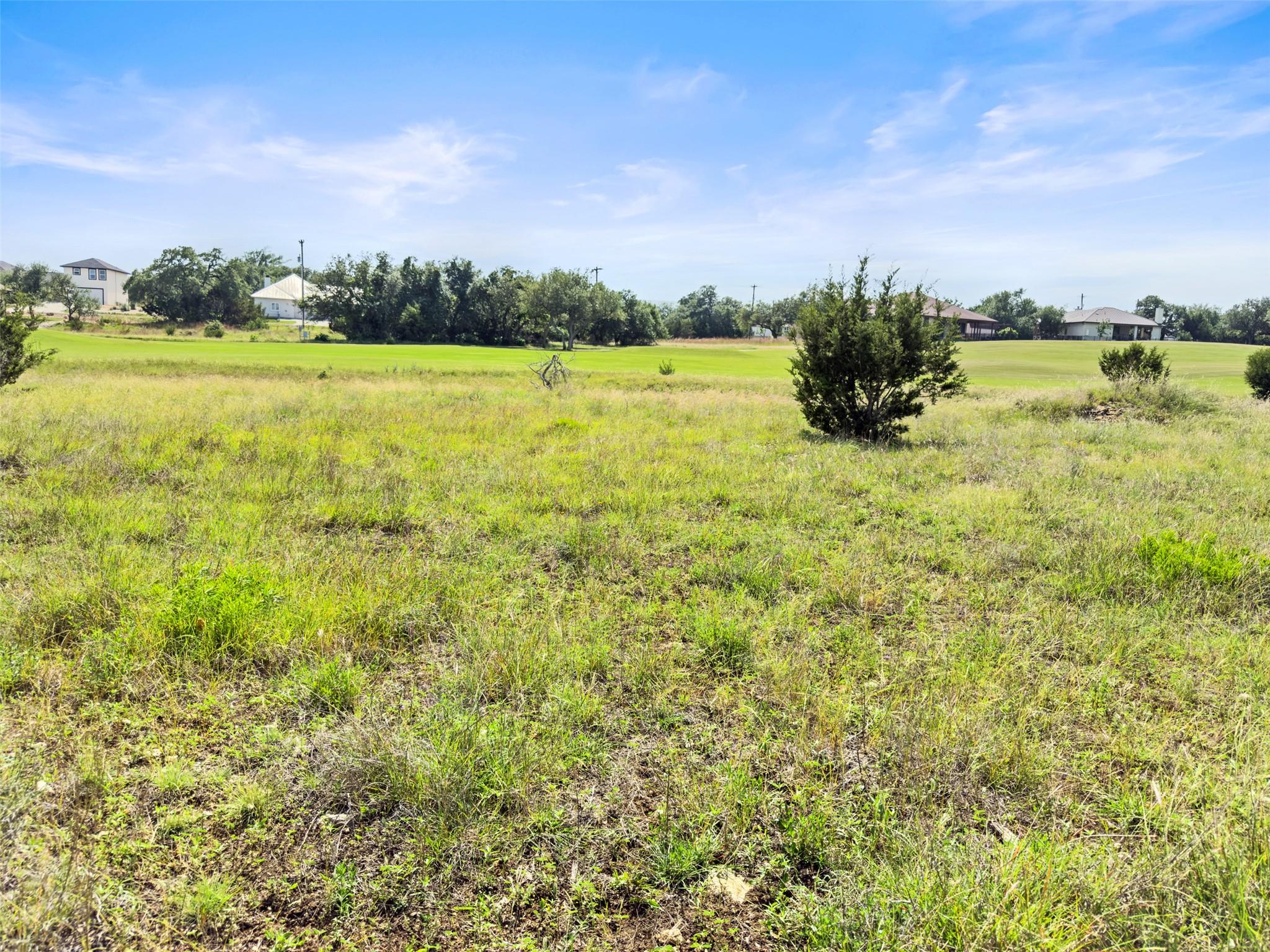 Rolling grassy fields back to a neighboring golf 