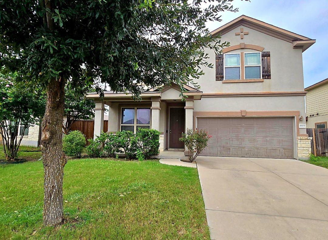 View of front of home with stucco siding, drivewa