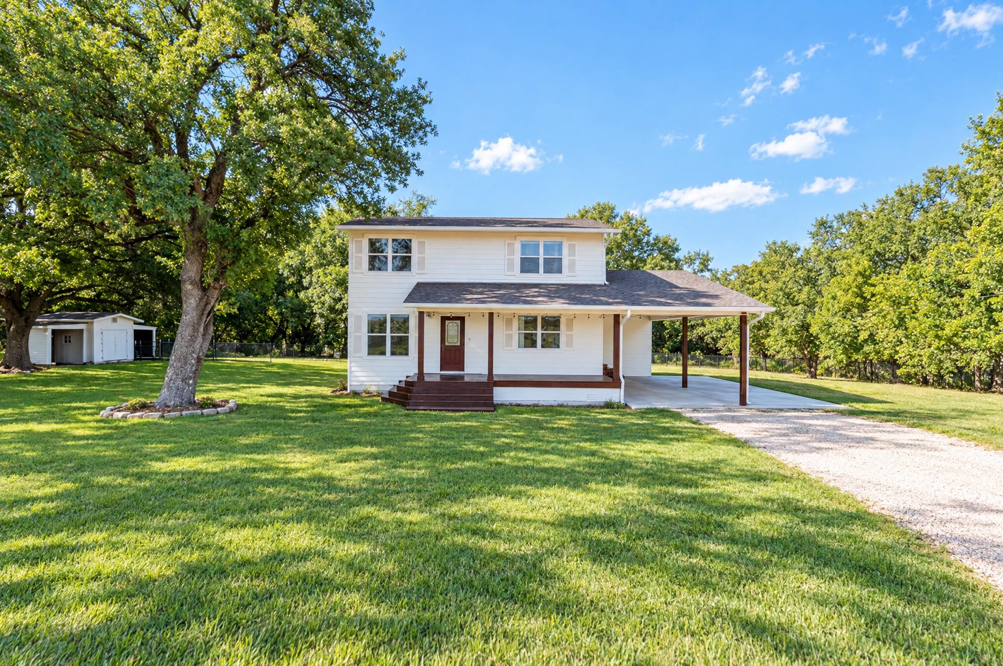 Mature trees shade the front porch of this tradit