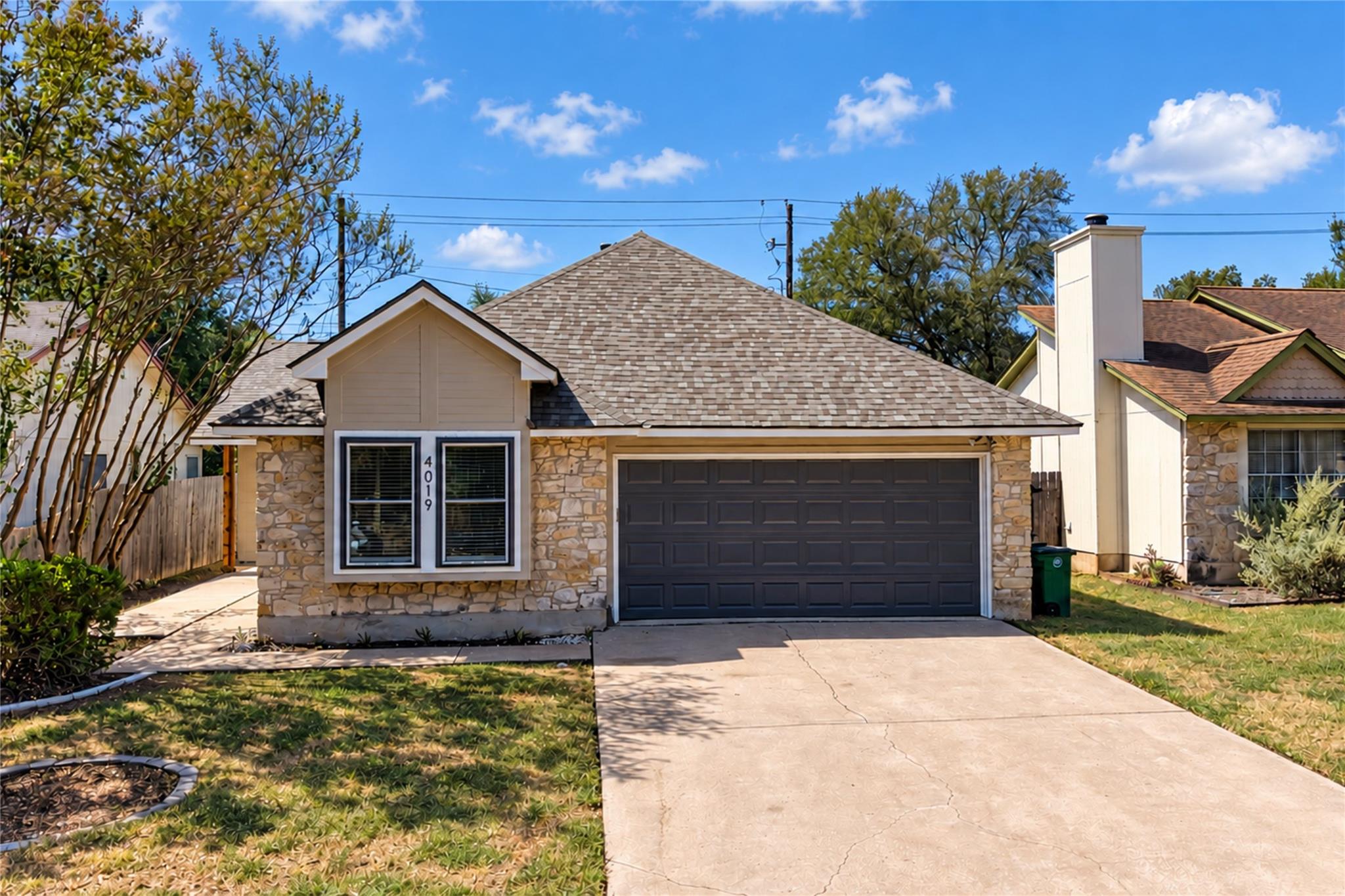 A classic stone facade and tidy concrete driveway