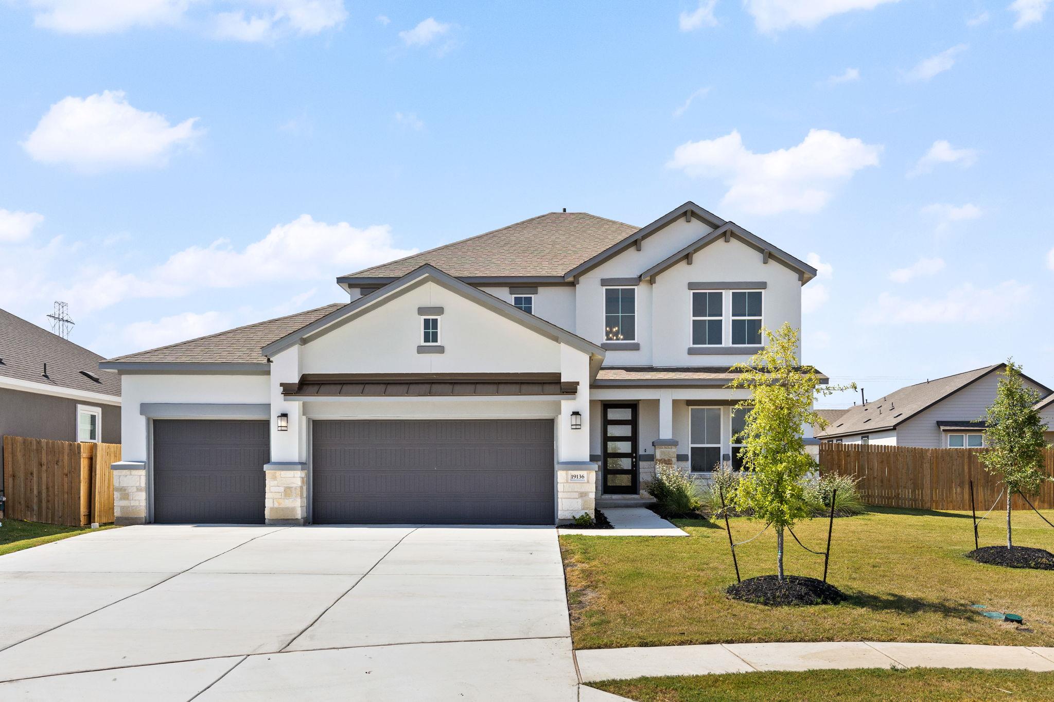 A concrete driveway leads to this modern two-stor