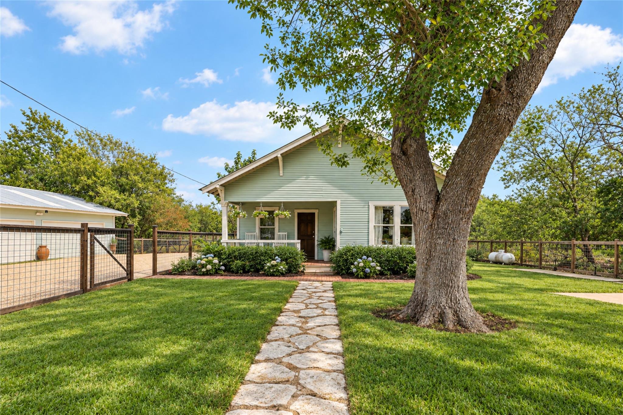 A stone pathway leads across a manicured lawn tow