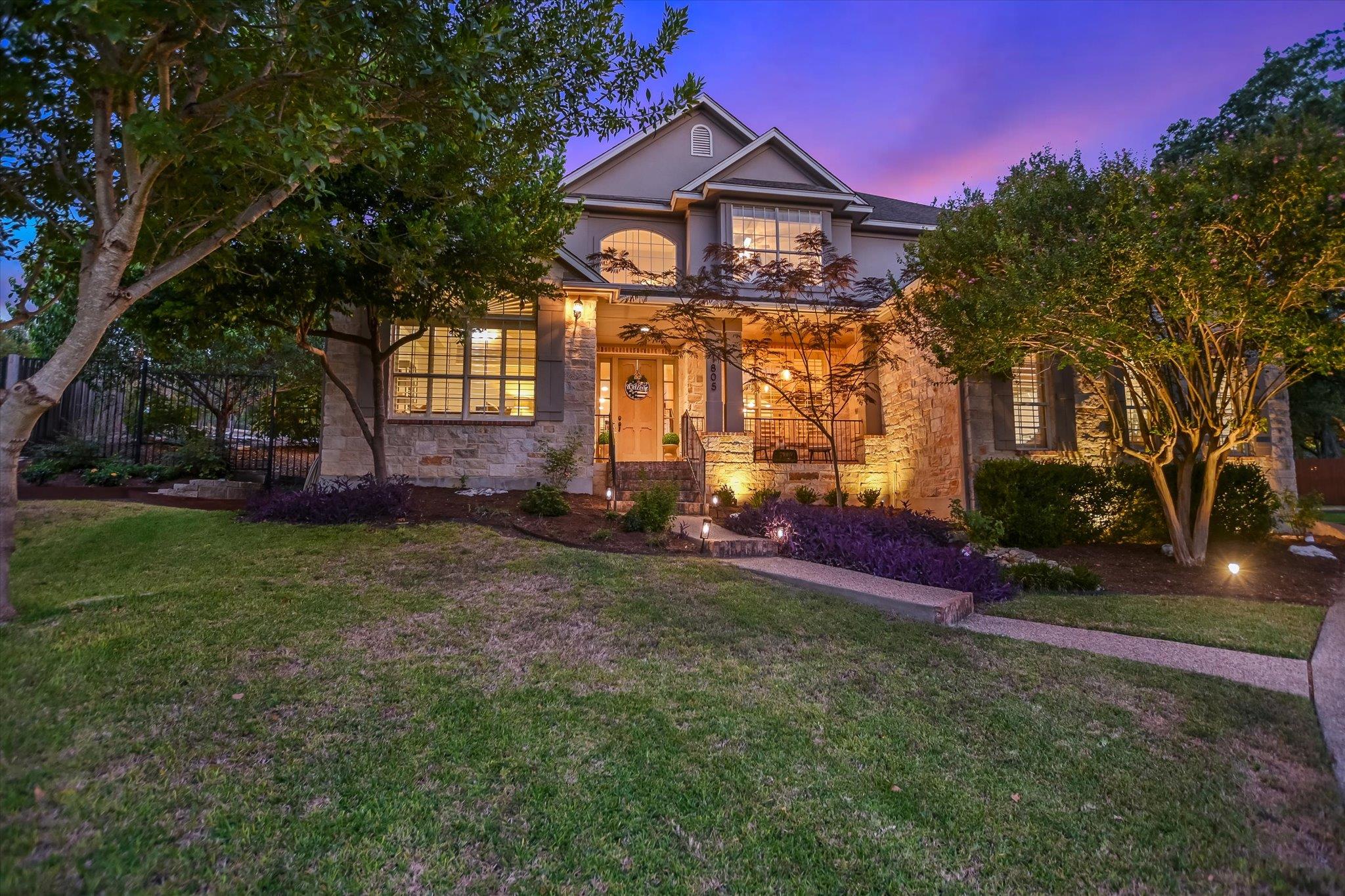 Mature trees frame a classic stone facade, highli