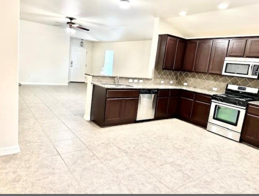 Tiled flooring flows through an open kitchen layo