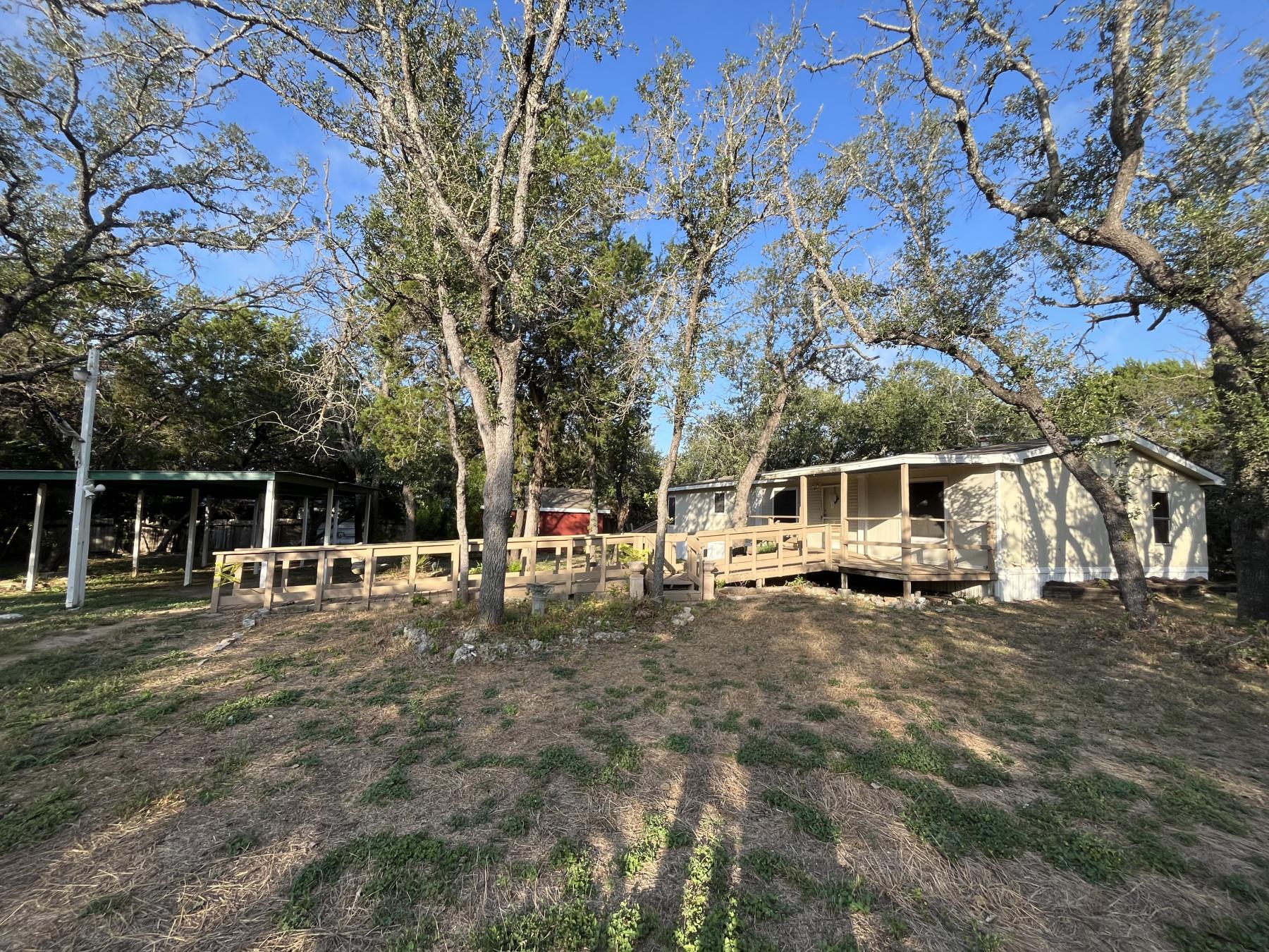 Mature trees frame a peaceful country home featur