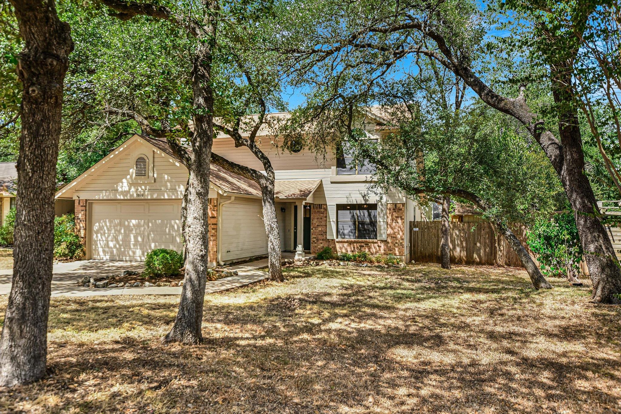Mature shade trees frame this traditional multi-l