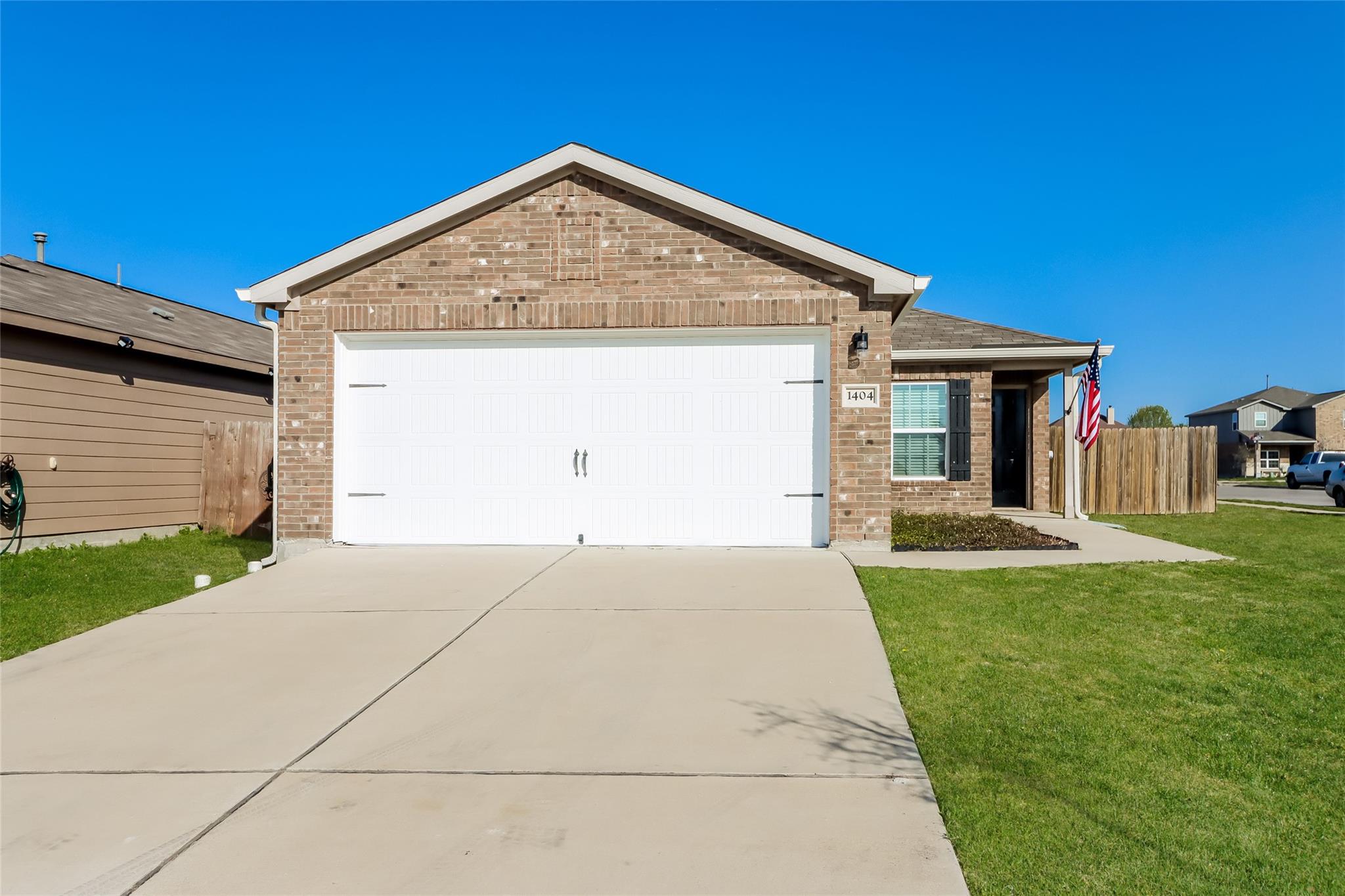 A spacious concrete driveway leads to the brick f