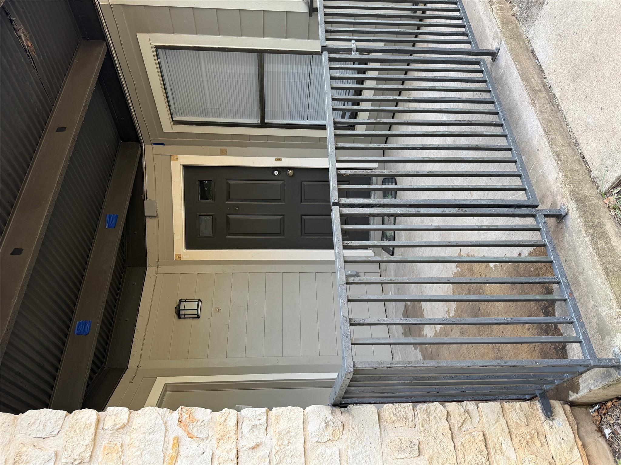Metal railings border a concrete front porch lead