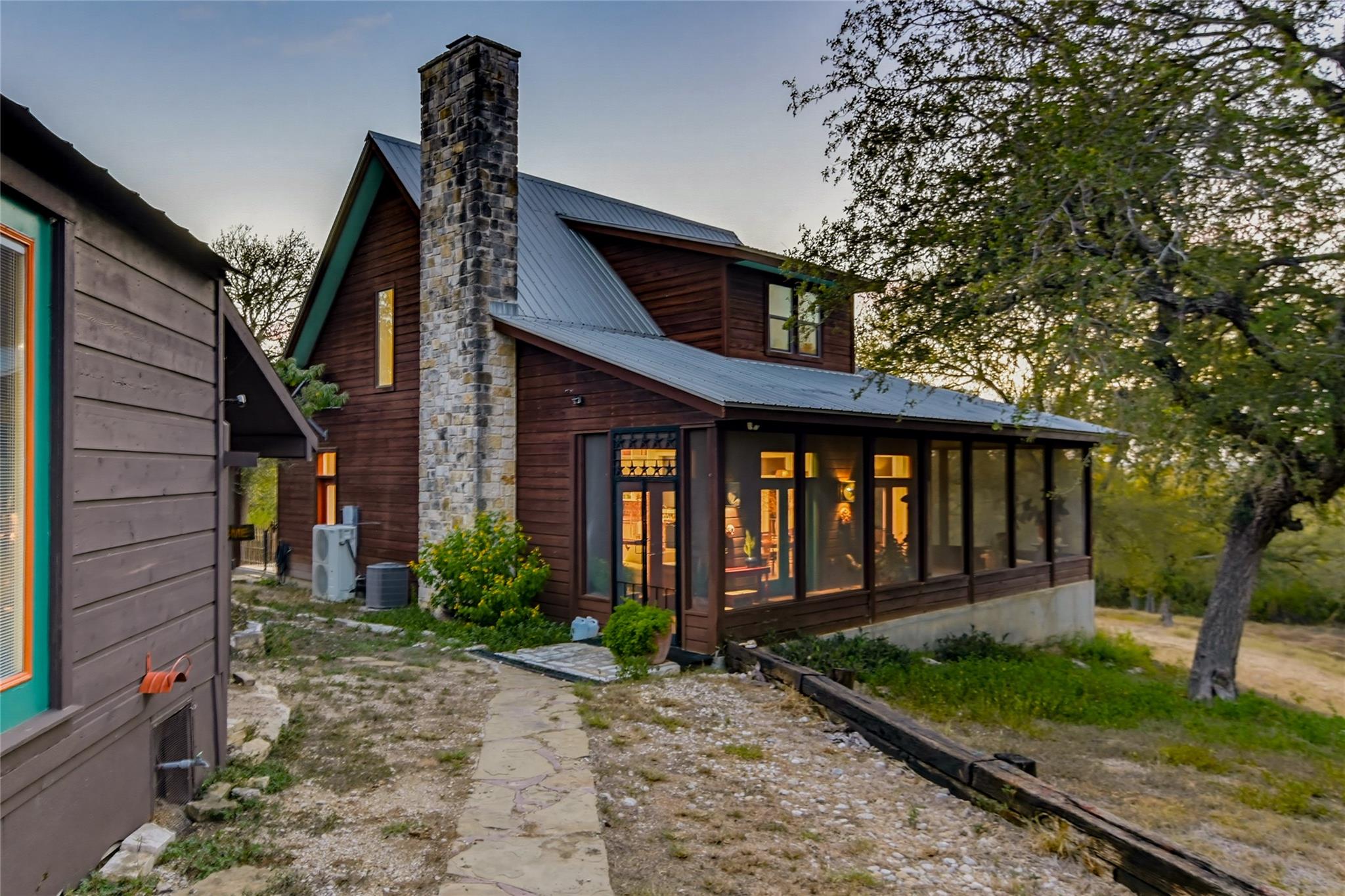 Warm wood siding and a prominent stone chimney de