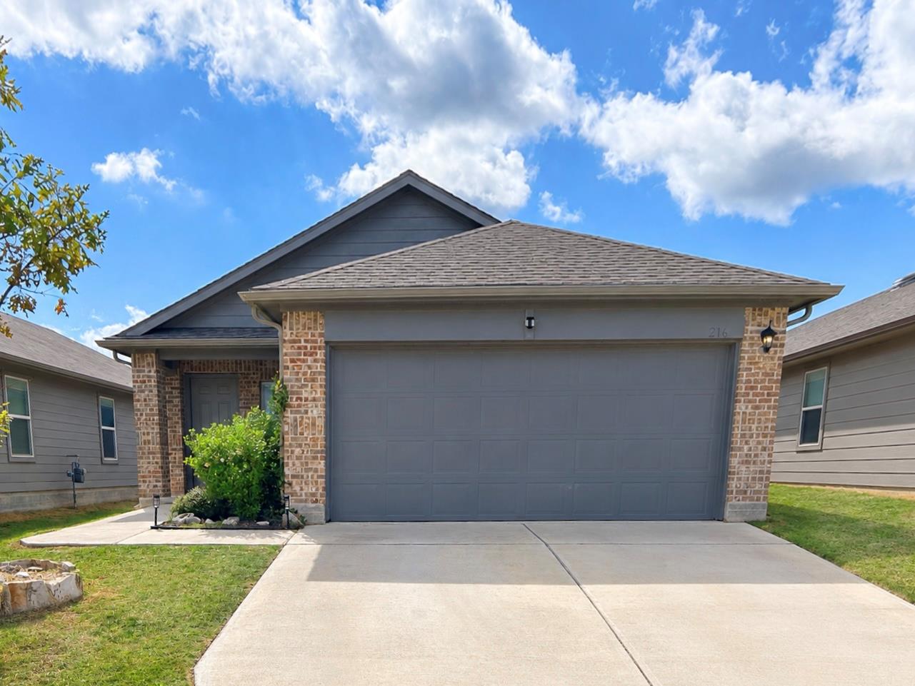Brick accents and a spacious concrete driveway de