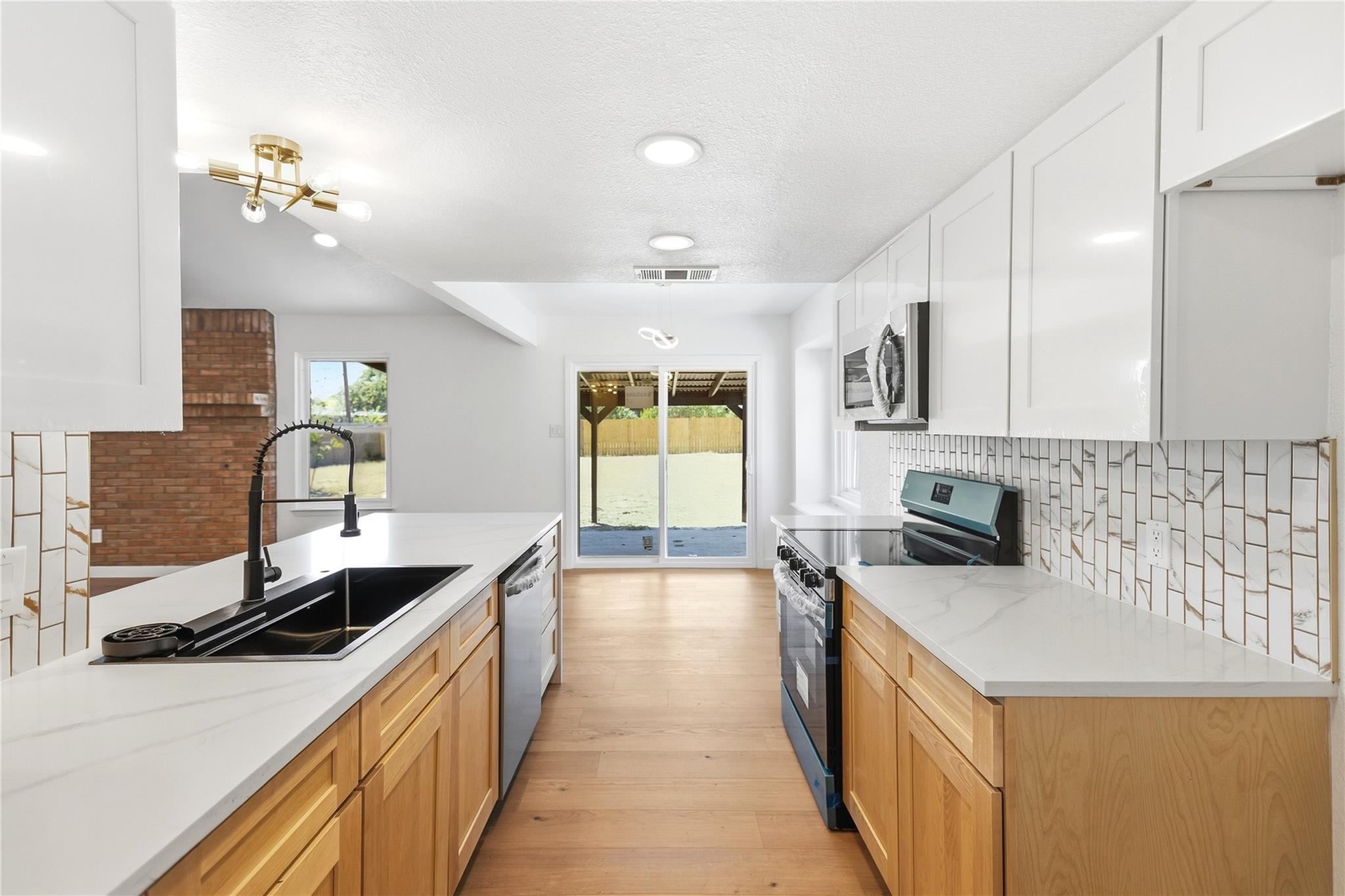 Warm wood cabinetry and stone counters anchor thi