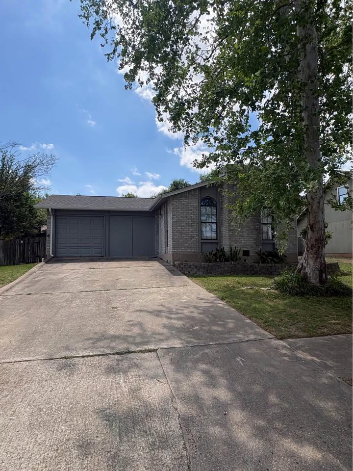 Mature trees shade a classic brick exterior compl