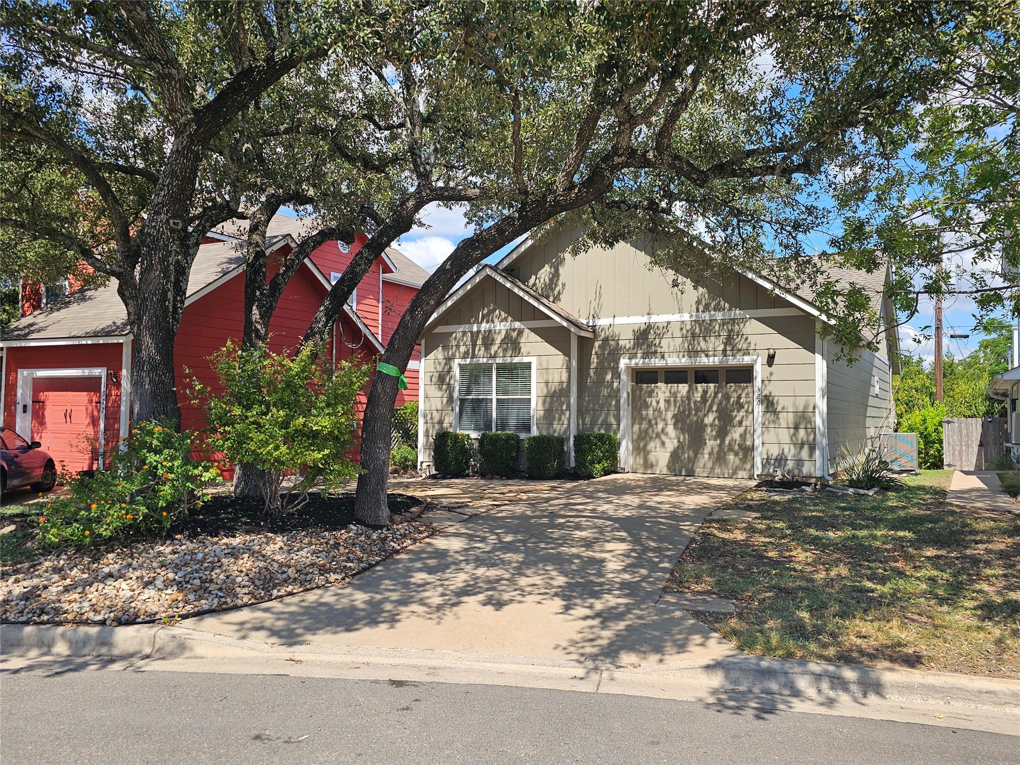 Mature trees shade a classic concrete driveway le