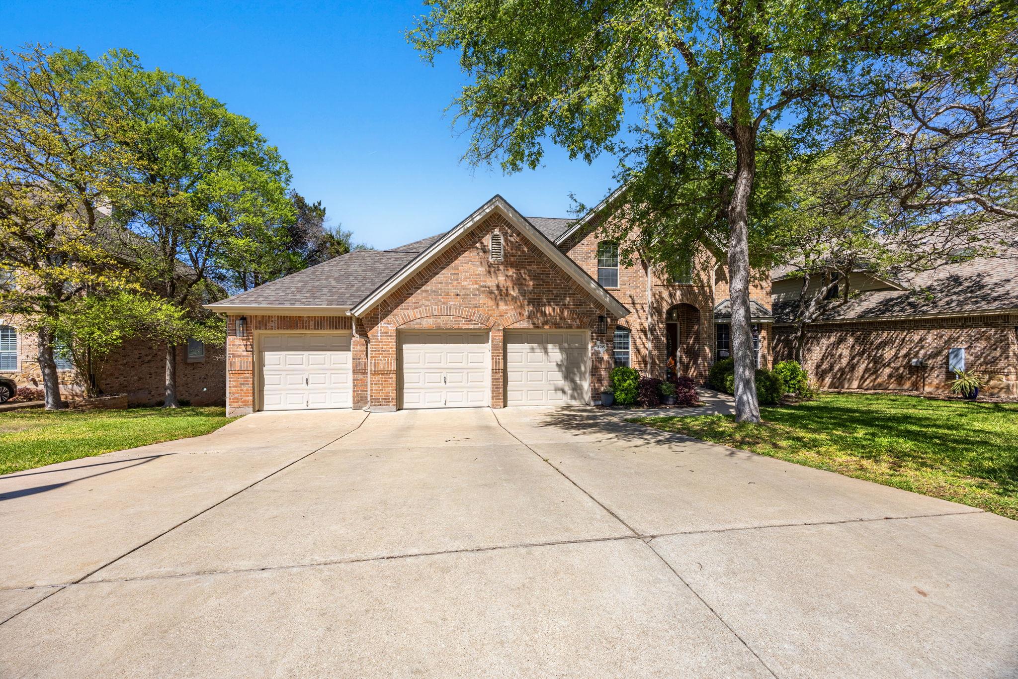 Mature trees shade a classic brick exterior with 