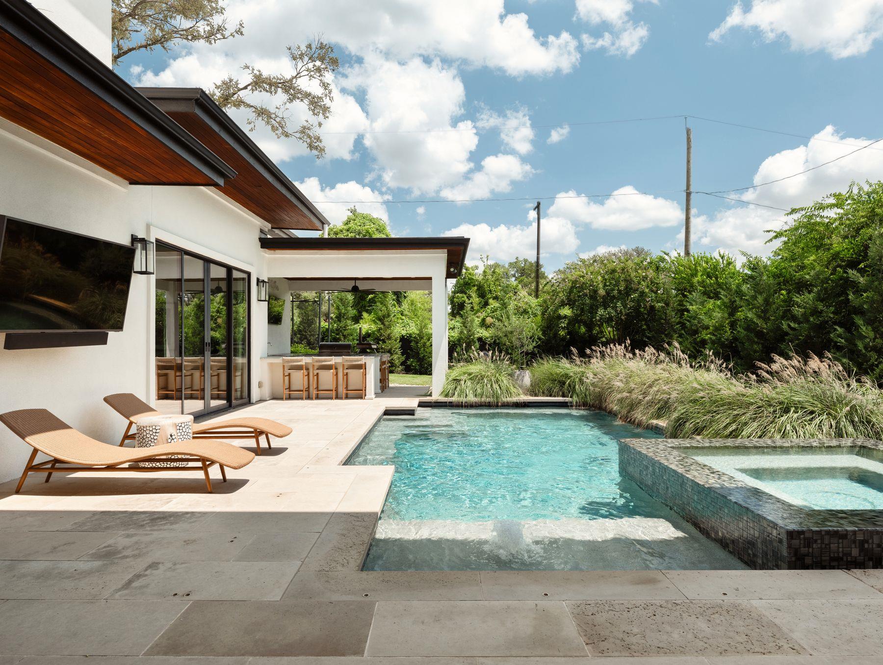 Lush landscaping frames a pristine pool and integ