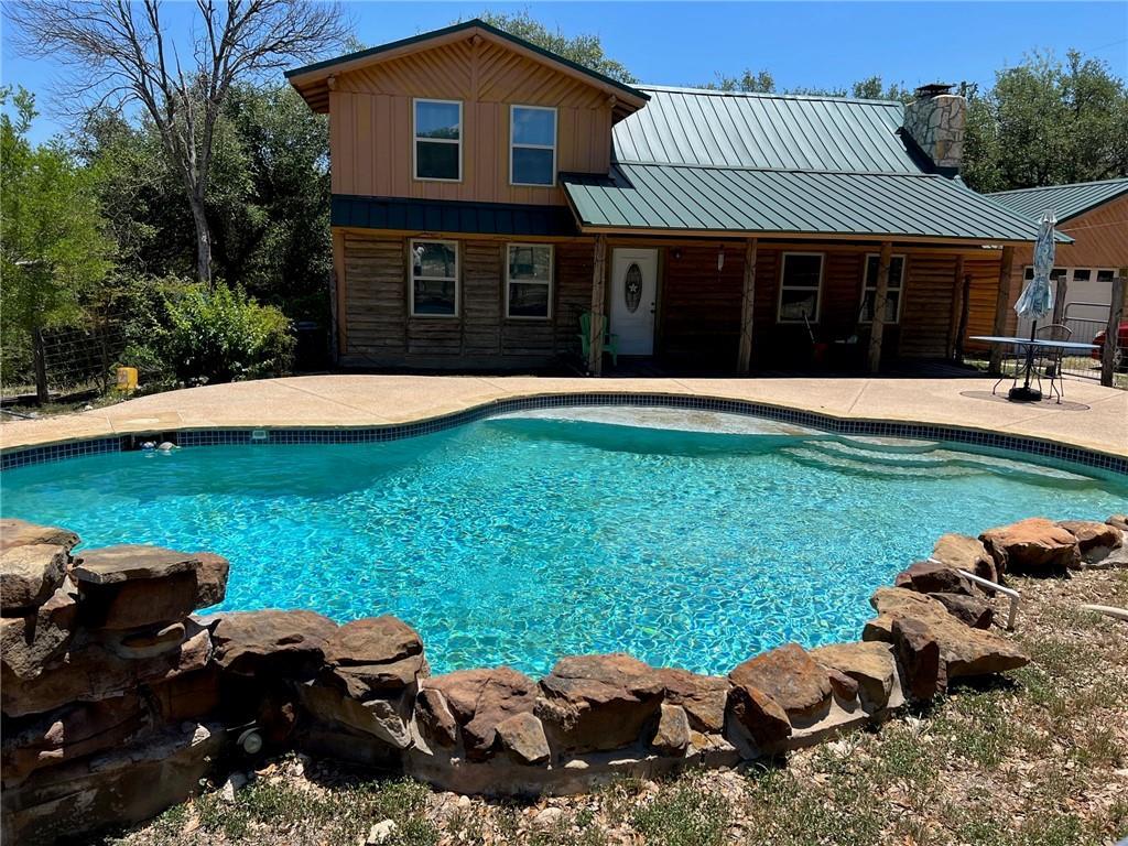 An inviting swimming pool sits in front of a rust