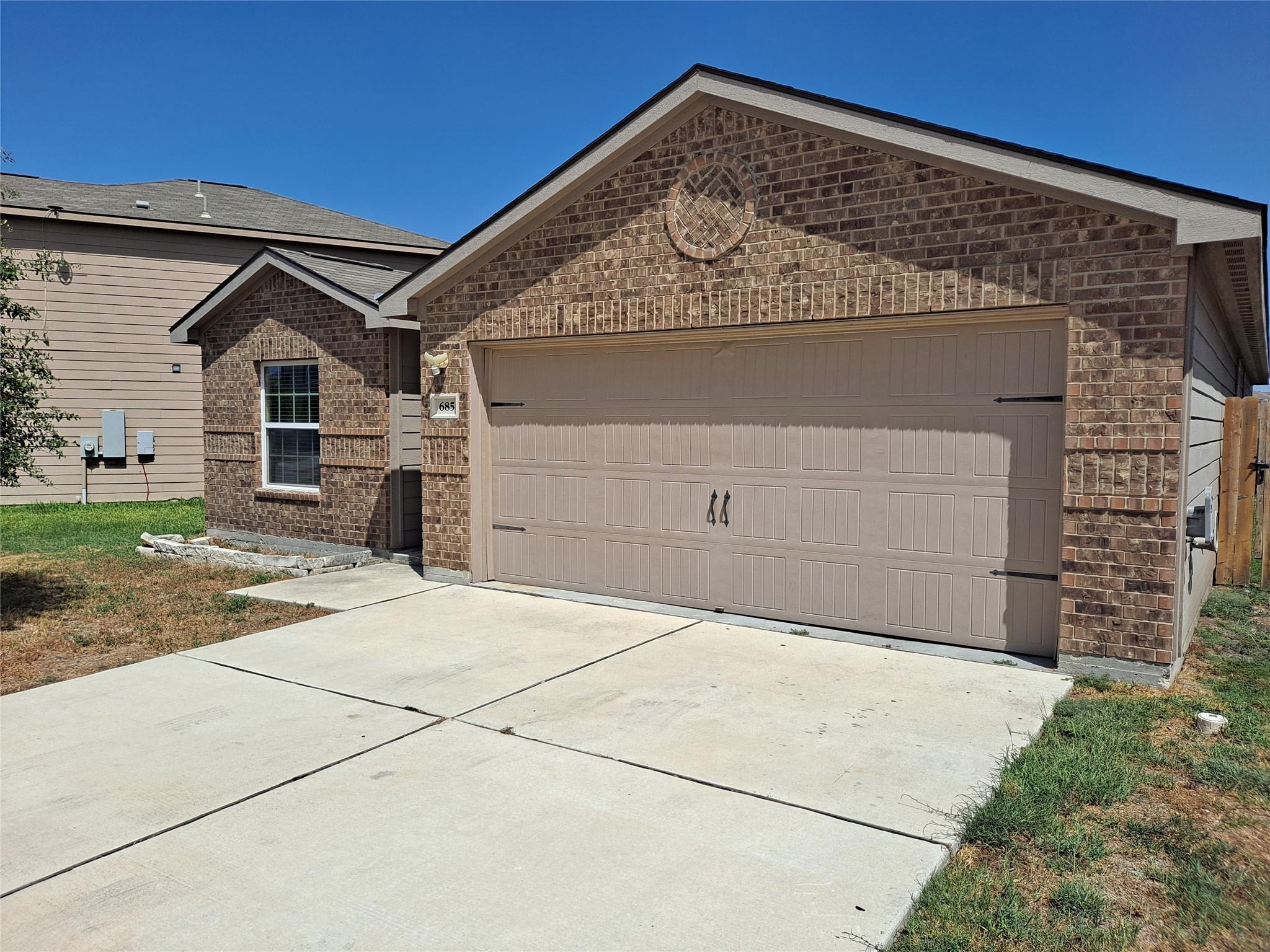 A classic brick exterior and concrete driveway le