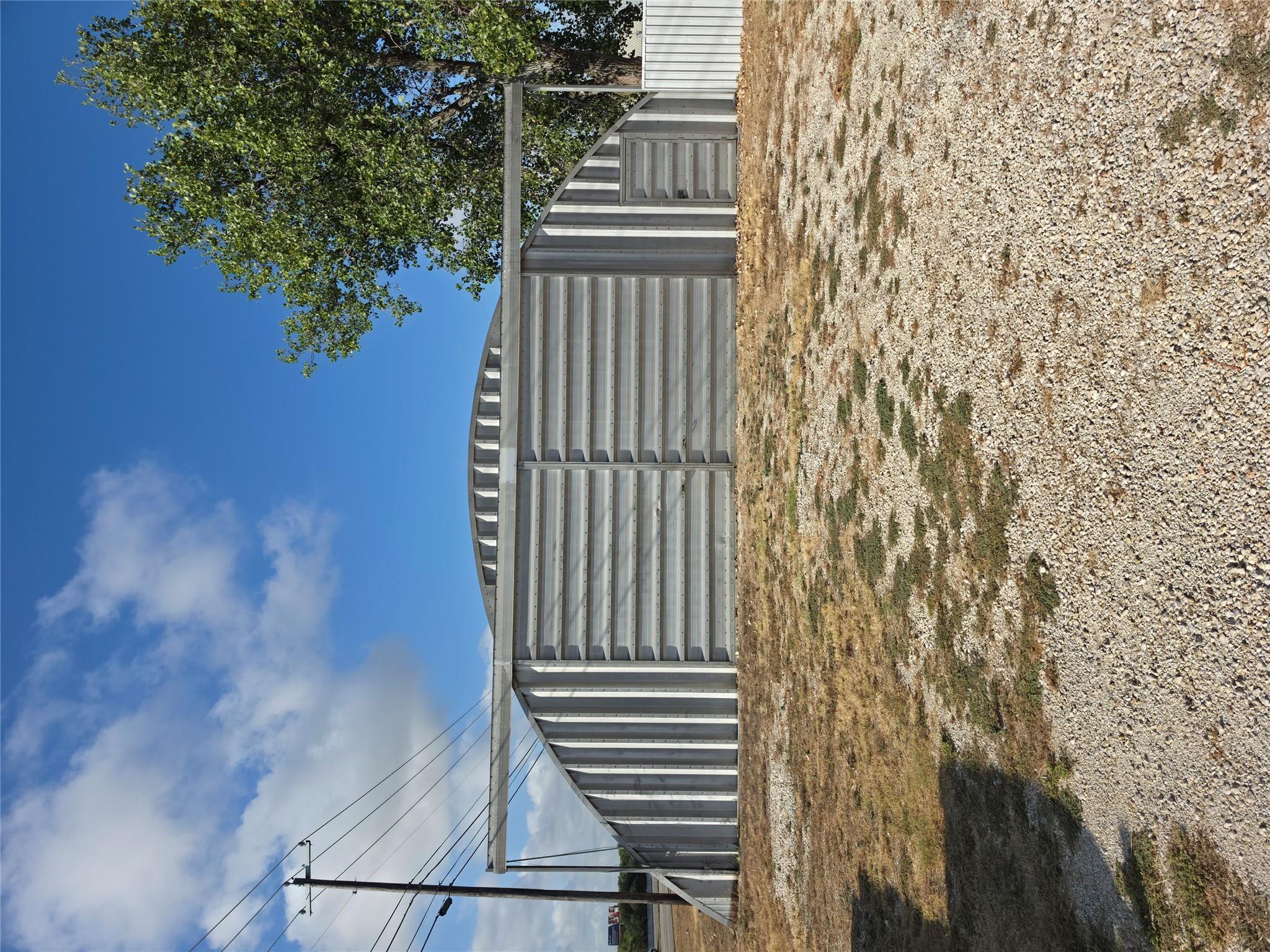 A spacious corrugated metal airplane hangar sits 