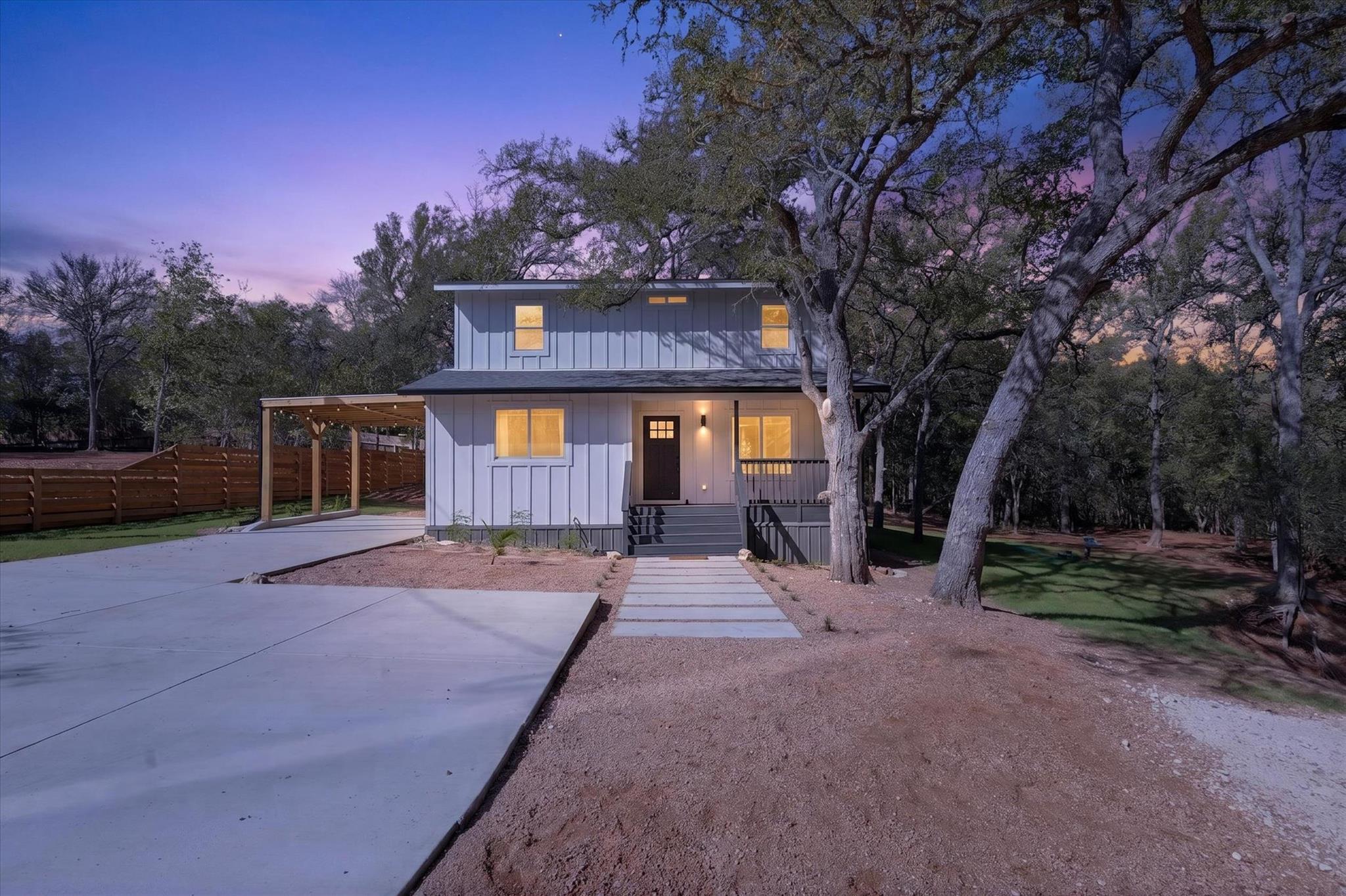 Mature trees frame a modern vertical siding exter